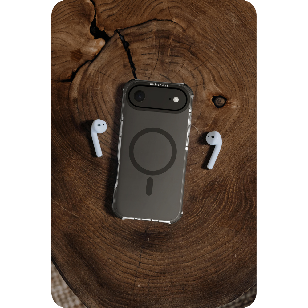 Un telefono in una custodia, con due auricolari bianchi, poggia su una superficie di legno. Il telefono ha una custodia trasparente e un retro grigio scuro.