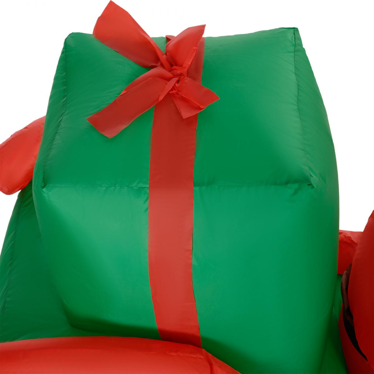 Eine große, aufblasbare grüne Geschenkbox mit rotem Band und Schleife. Der Hintergrund ist weiß.