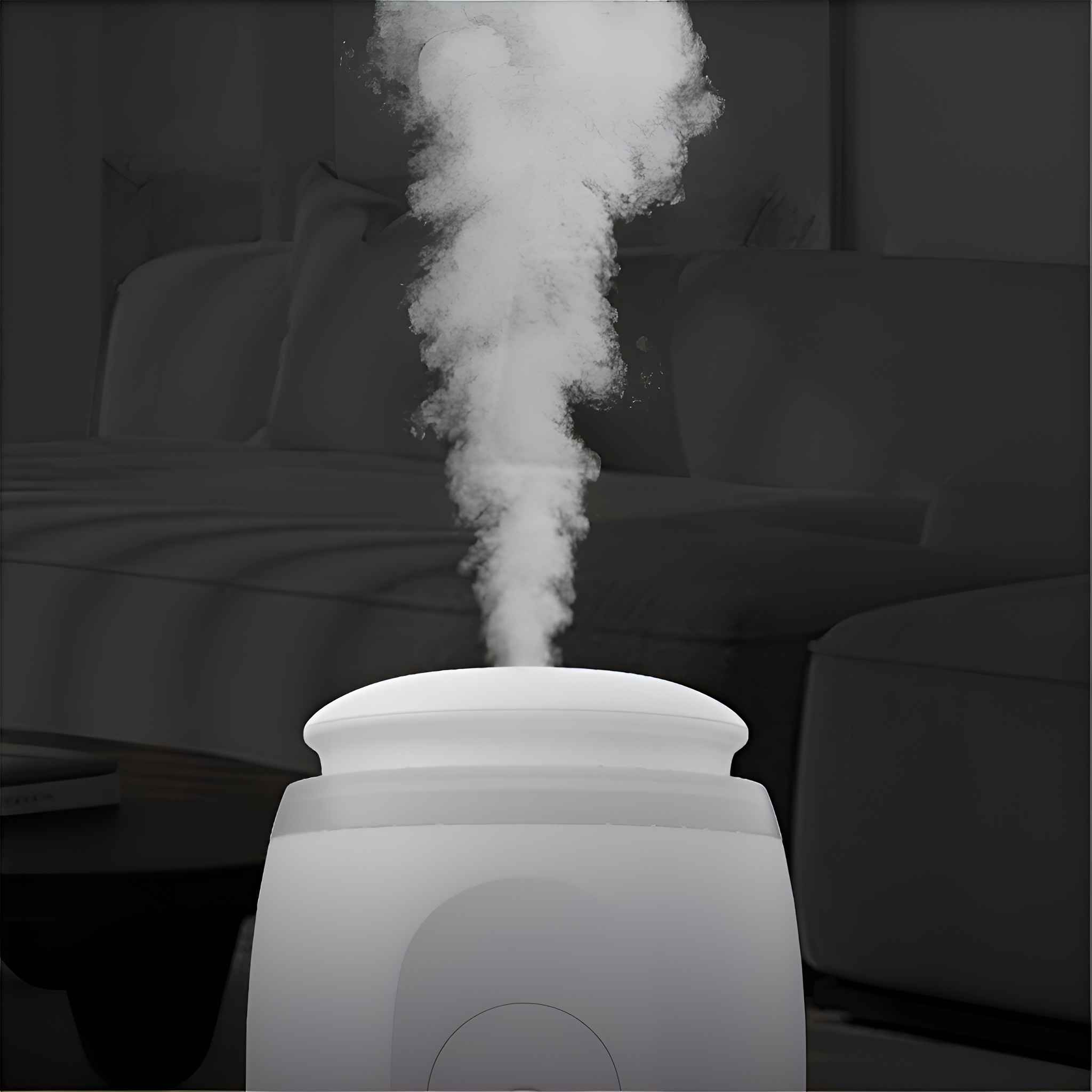 Ein weißer Luftbefeuchter gibt eine Dampfwolke ab. Im Hintergrund ist ein verschwommenes Schlafzimmer mit Bett und Möbeln zu sehen.