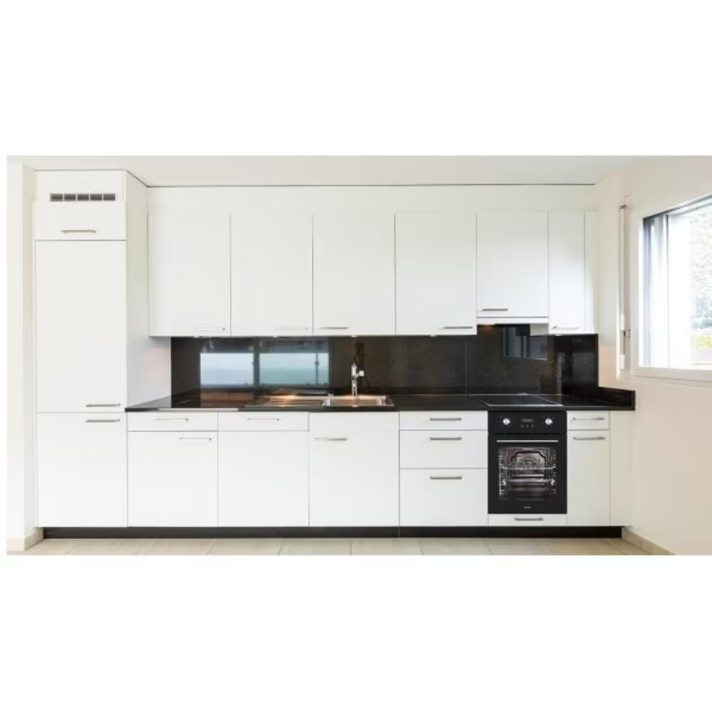 Nowoczesna biała kuchnia z czarnymi blatami, zlewozmywakiem ze stali nierdzewnej i piekarnikiem. Okno po prawej.