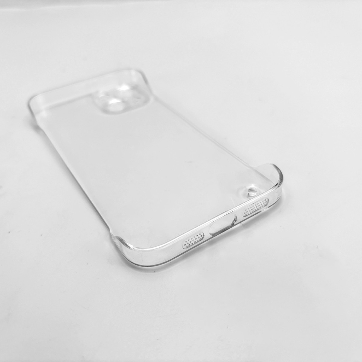 Una custodia trasparente per telefono è appoggiata su una superficie bianca. La custodia è rettangolare con angoli arrotondati e aperture.