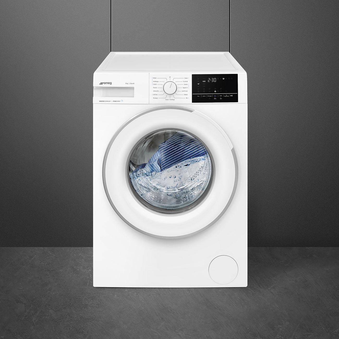 Una lavatrice Smeg bianca. La porta è aperta, rivelando i vestiti all'interno. Lo sfondo è una parete e un pavimento grigio scuro.