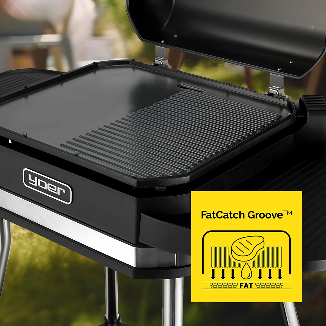 Zbliżenie czarnego grilla Yoer. Grill ma płaską powierzchnię i rowkowaną sekcję. Diagram podkreśla system FatCatch Groove.