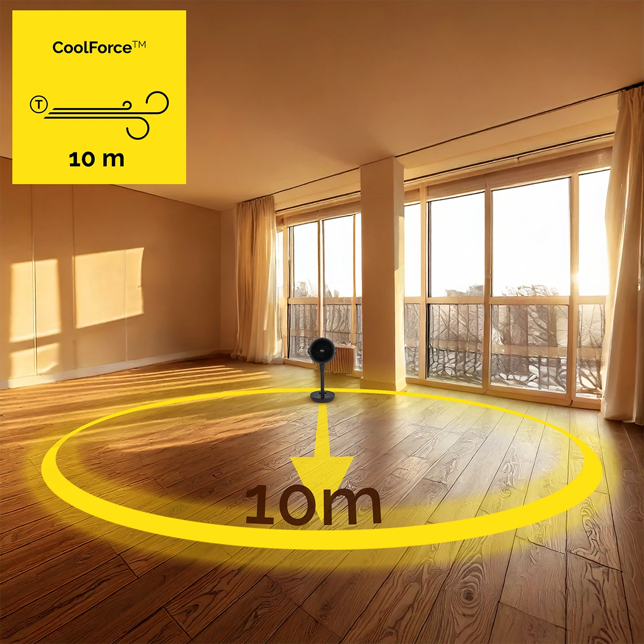 Czarny wentylator w pokoju z drewnianą podłogą. Żółte koło i strzałka wskazują zasięg 10m. Duże okna ze drzewami.