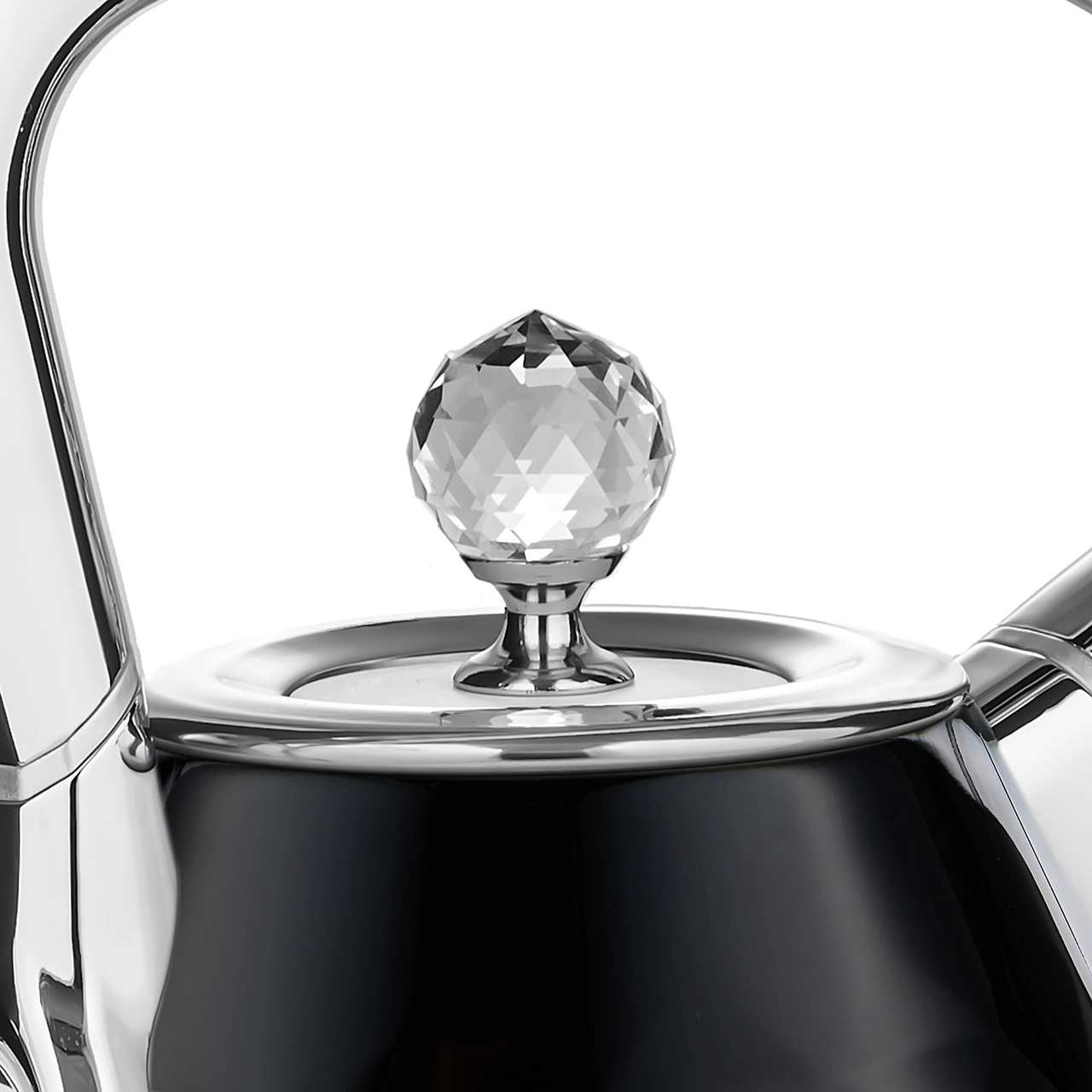 Zbliżenie czarnego czajnika z kryształowym pokrętłem. Czajnik jest błyszczący, z metalicznymi akcentami. Białe tło.