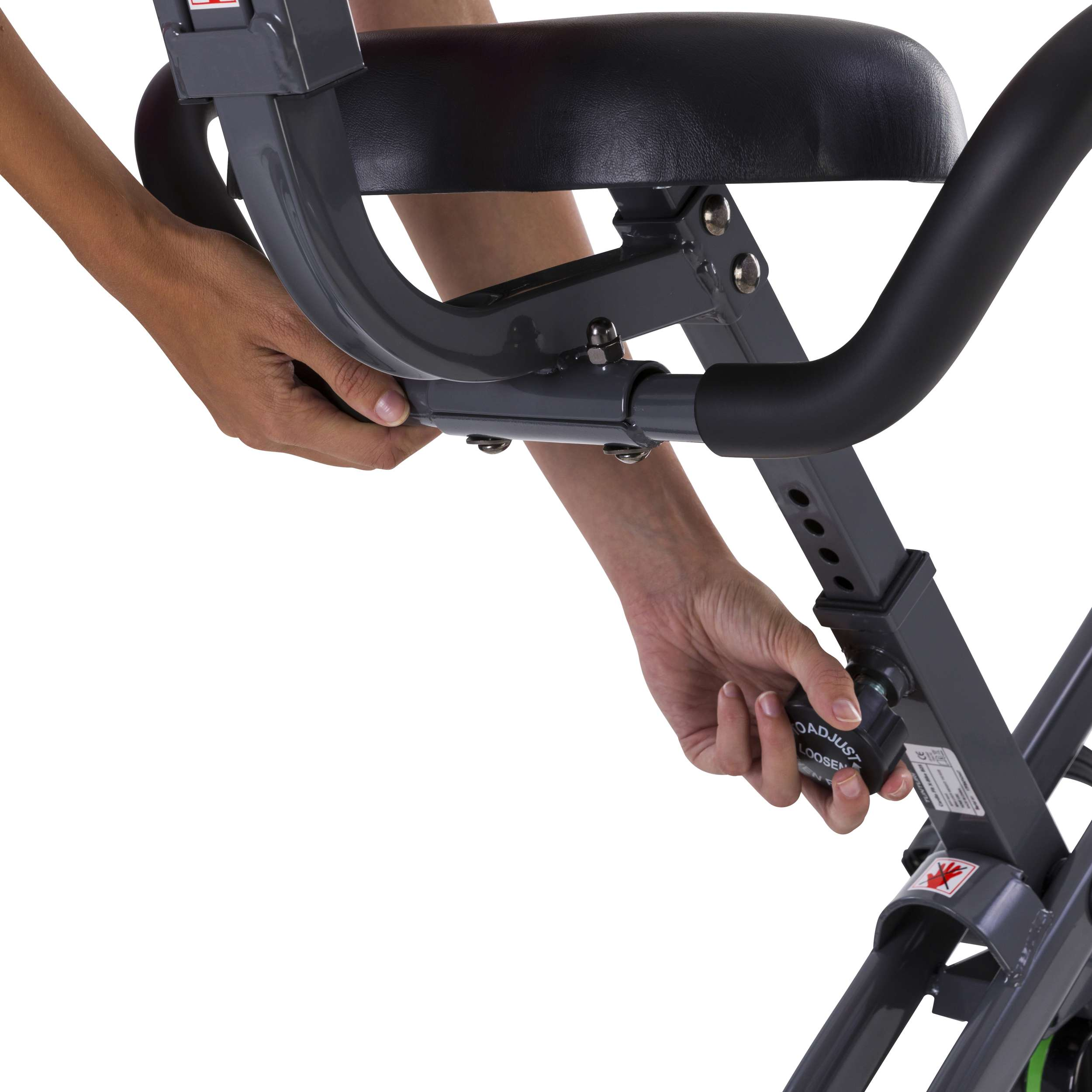 Handen van een persoon die een hometrainer afstelt. De zitting en het frame zijn zichtbaar. De achtergrond is wit.