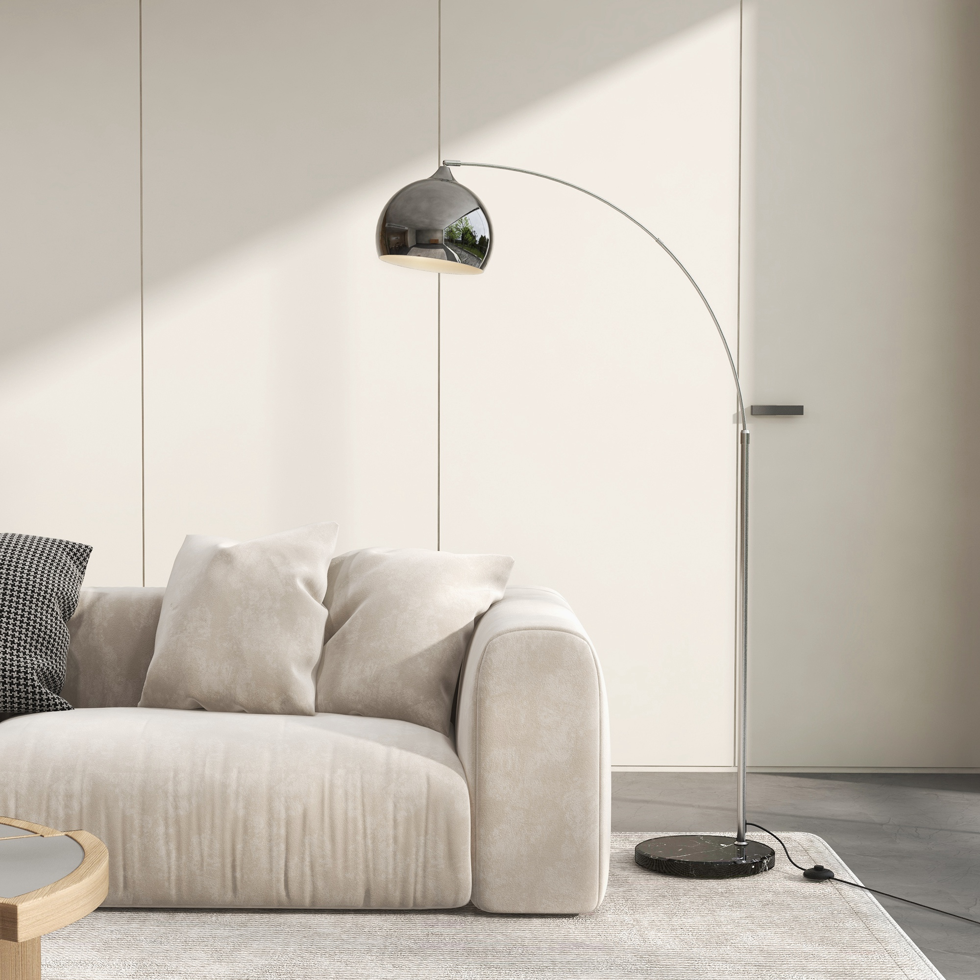 Un interno moderno presenta un divano beige, una lampada ad arco e un tappeto. La lampada ha un paralume a specchio. Il muro è beige chiaro.