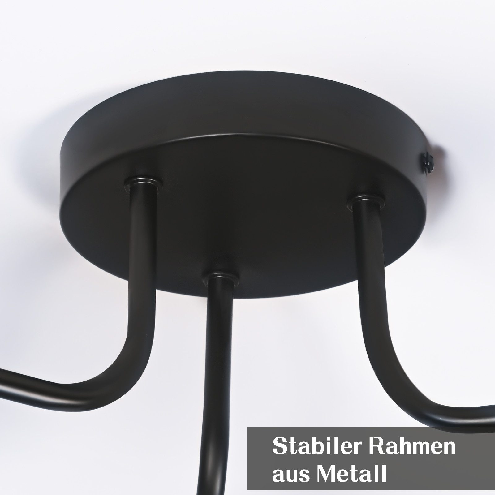 Primo piano di un lampadario in metallo nero su sfondo bianco. Il lampadario ha una base circolare e bracci curvi.