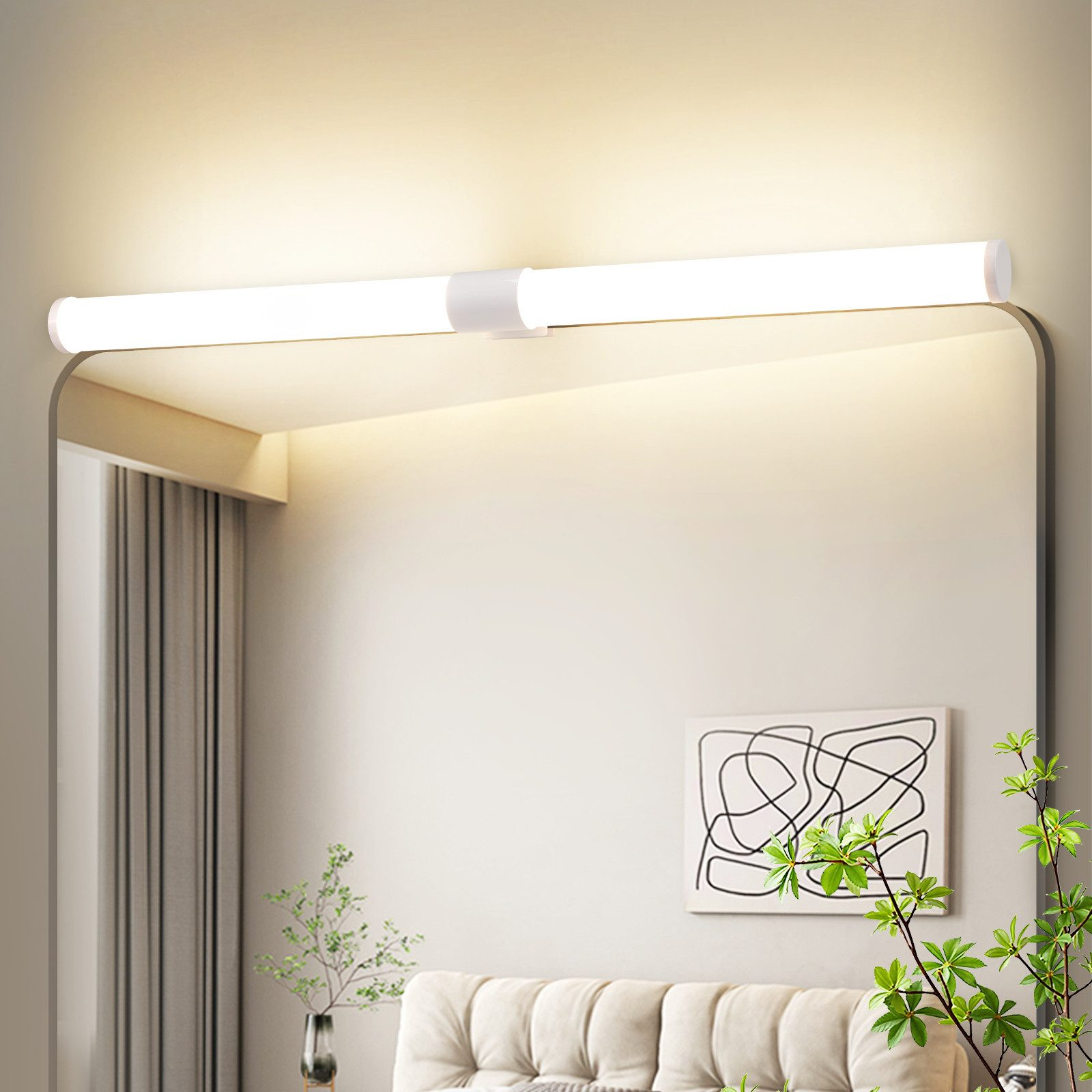 Una lampada LED bianca illuminata sopra uno specchio. Un disegno sul muro e una pianta sul bordo destro sono visibili.