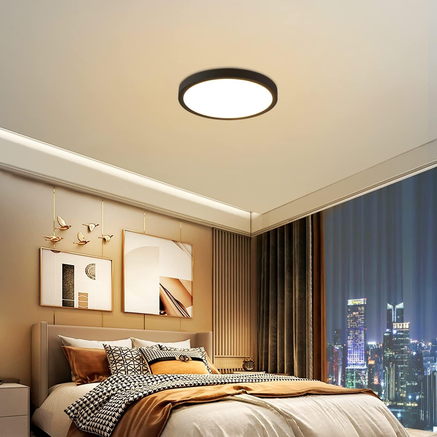 Camera da letto con letto grande, arte e vista sulla città di notte. Sono visibili anche la luce a soffitto e le tende.