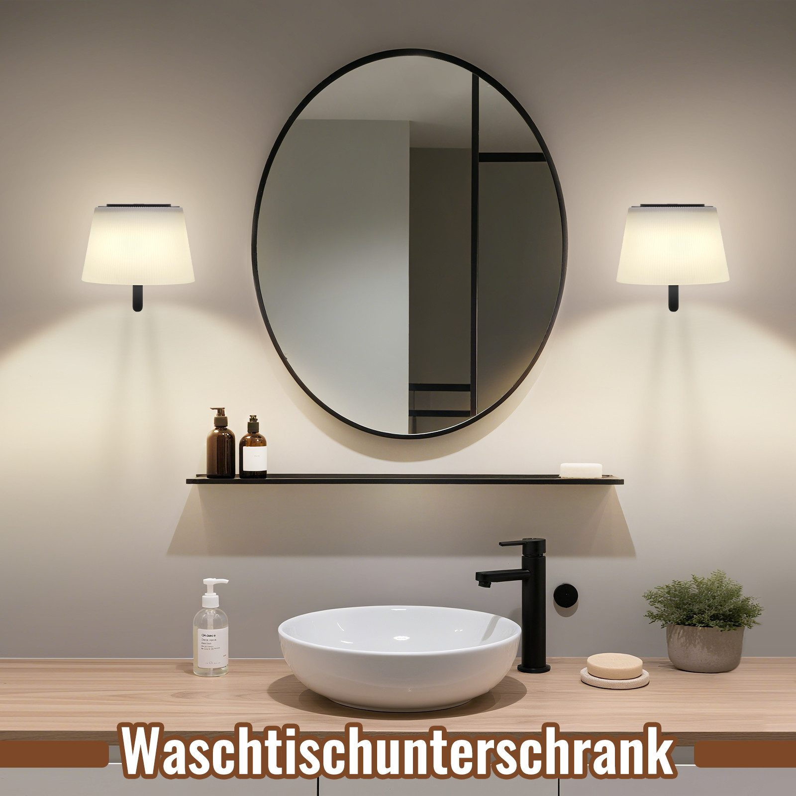 Interno bagno. Specchio ovale, lampade, mensola con bottiglie, lavandino bianco, rubinetto nero, sapone, pianta e piano in legno.