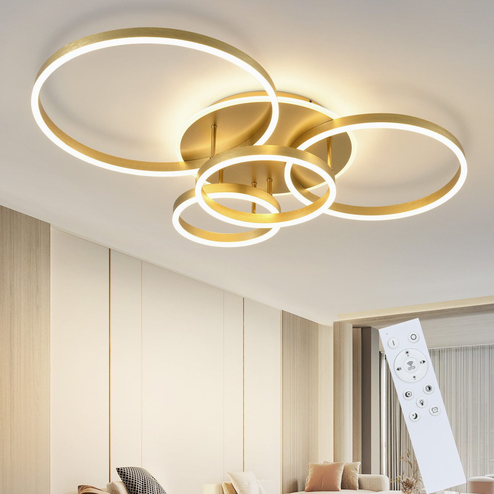 Una lampada da soffitto dorata e circolare con telecomando in un moderno soggiorno. Muri bianchi, divano color crema e cuscini decorativi.