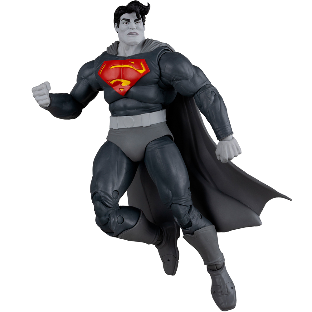 Action figure di Superman in volo, tuta grigio scuro, emblema rosso e giallo, mantello nero, pelle grigia, pugno chiuso.