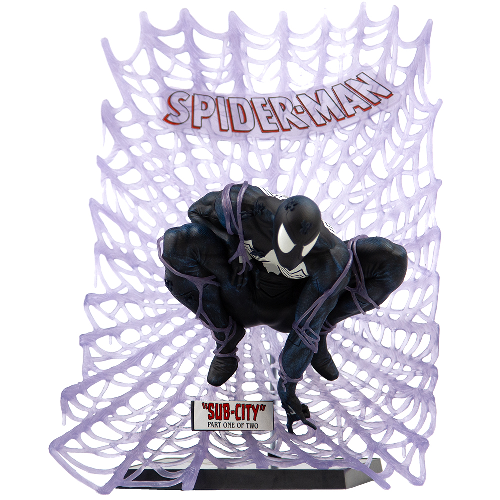 Una statuetta di Spider-Man accovacciata, con ragnatele, contro uno sfondo di ragnatela viola. La figura è per lo più nera con occhi bianchi.