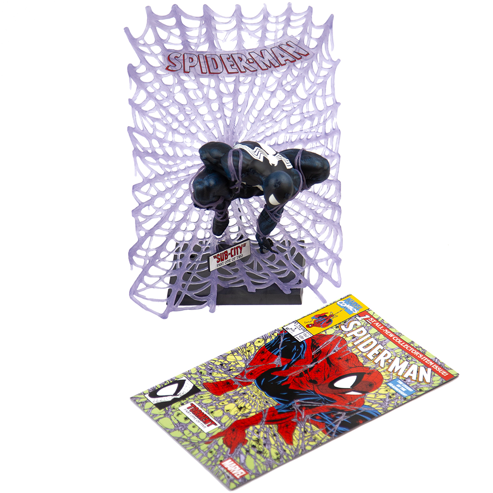 Figura di Spider-Man in bianco e nero, di fronte a una ragnatela viola. È presente anche un fumetto con Spider-Man.