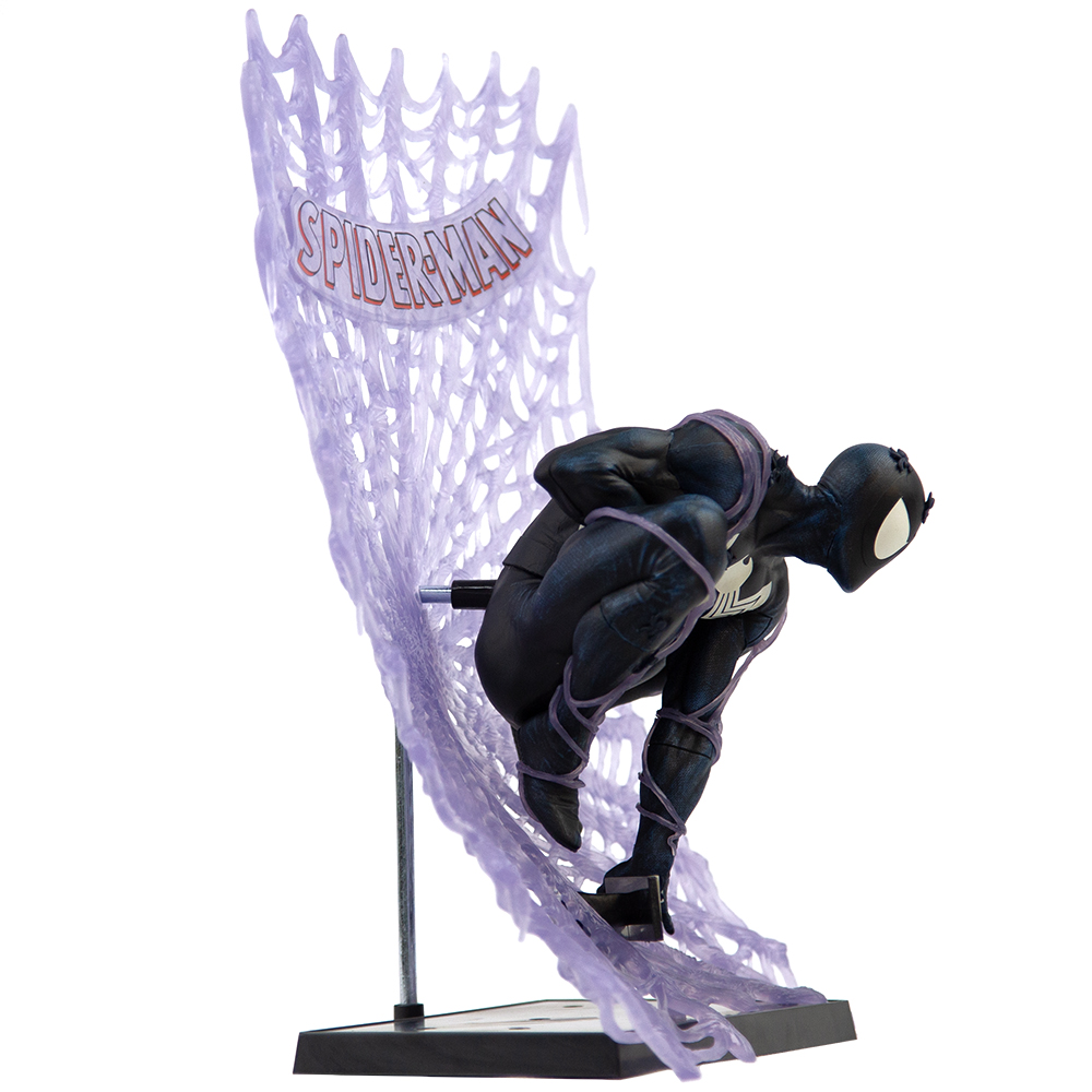 Una statuetta di Spider-Man in tuta nera, accovacciata davanti a una ragnatela viola con il logo di Spider-Man. Una base nera sostiene la statuetta.