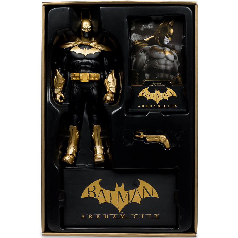 Un action figure di Batman in scatola. È nero e oro, con un supporto e accessori. La scatola dice Batman: Arkham City.