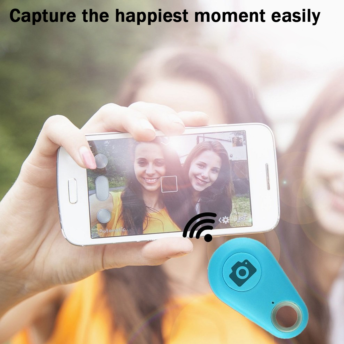 Eine Person hält ein Handy, das ein Selfie mit zwei Mädchen macht. Eine blaue Fernbedienung befindet sich im Vordergrund. Der Text lautet: 'Erfassen Sie ganz einfach den glücklichsten Moment'.