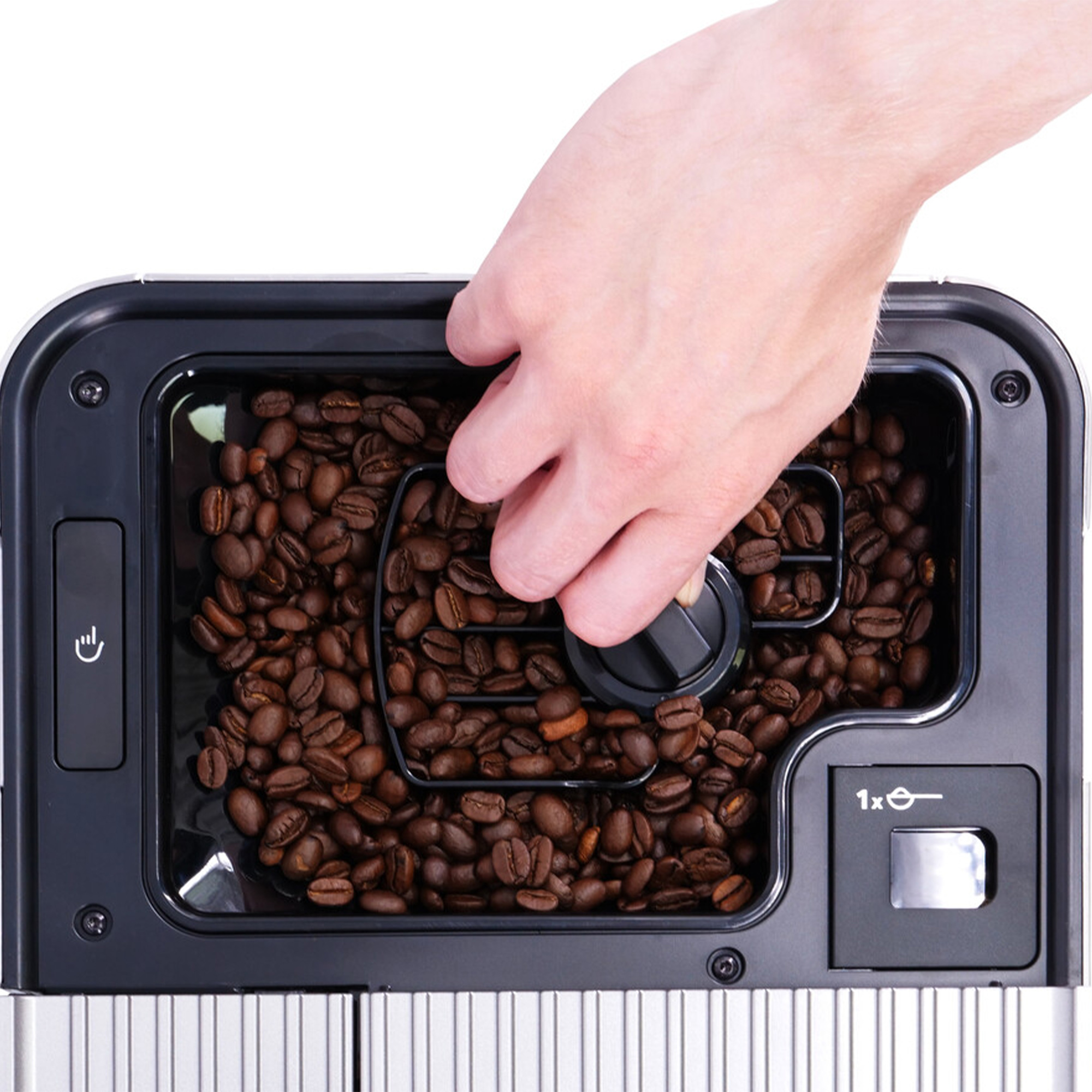 Hand die een zwart deksel in de bonencontainer van een koffiezetapparaat plaatst, gevuld met gebrande koffiebonen.