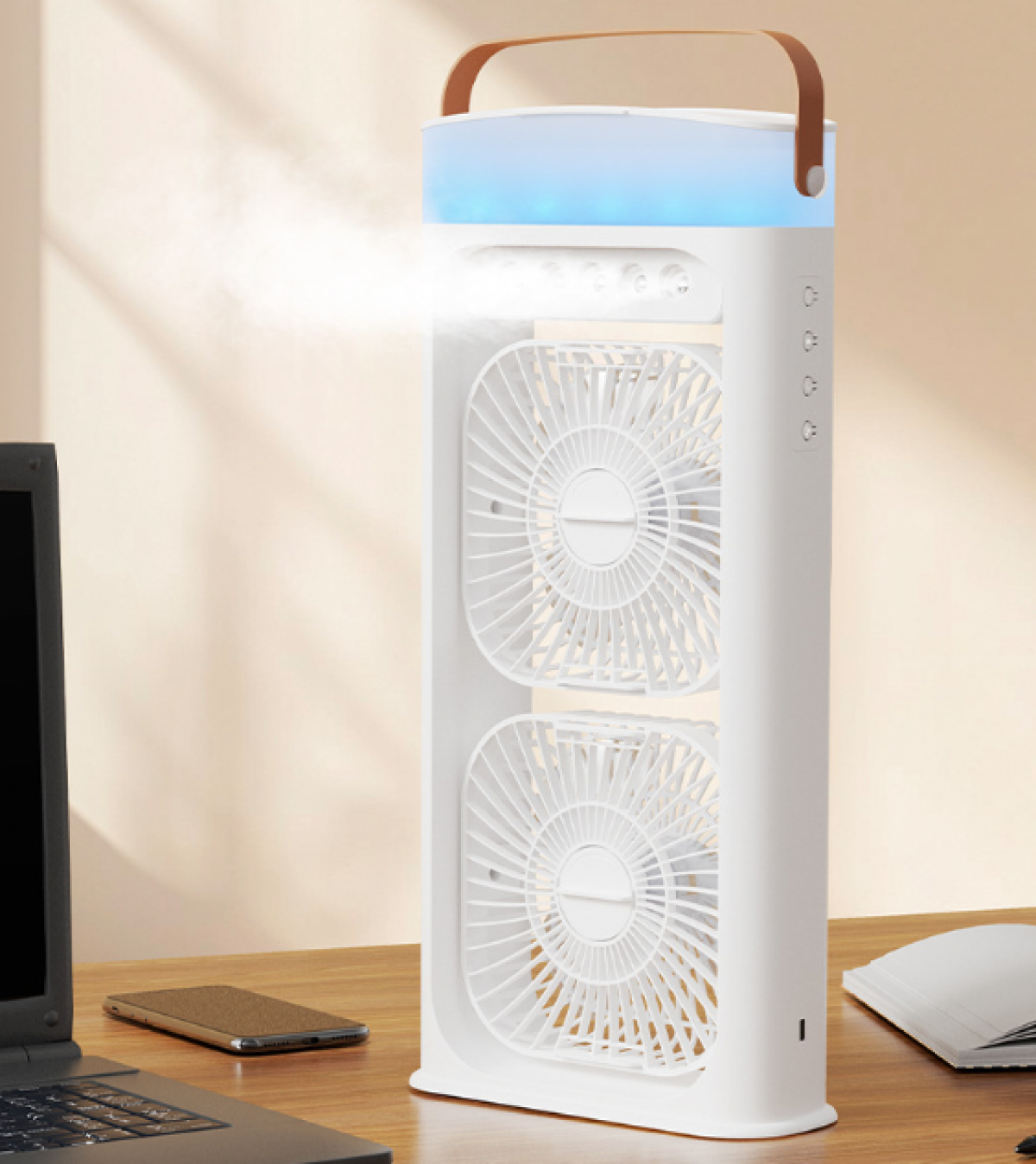 Ein weißer Luftkühler mit zwei Ventilatoren, einem braunen Griff und einem blauen Licht steht auf einem Holztisch neben einem Laptop und einem Telefon.