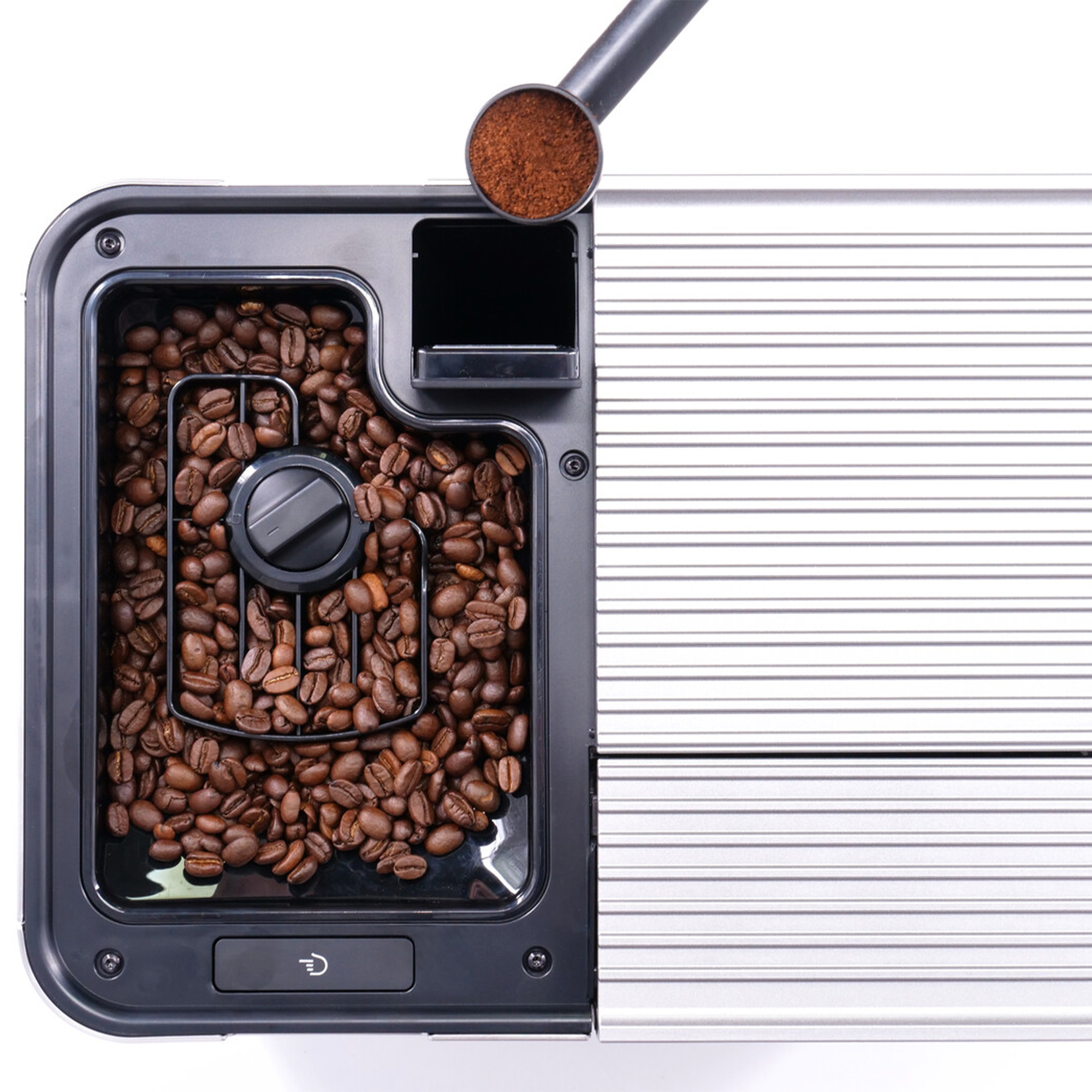 Koffiemachine gevuld met bonen, een schepje gemalen koffie en een paneel met horizontale lijnen.