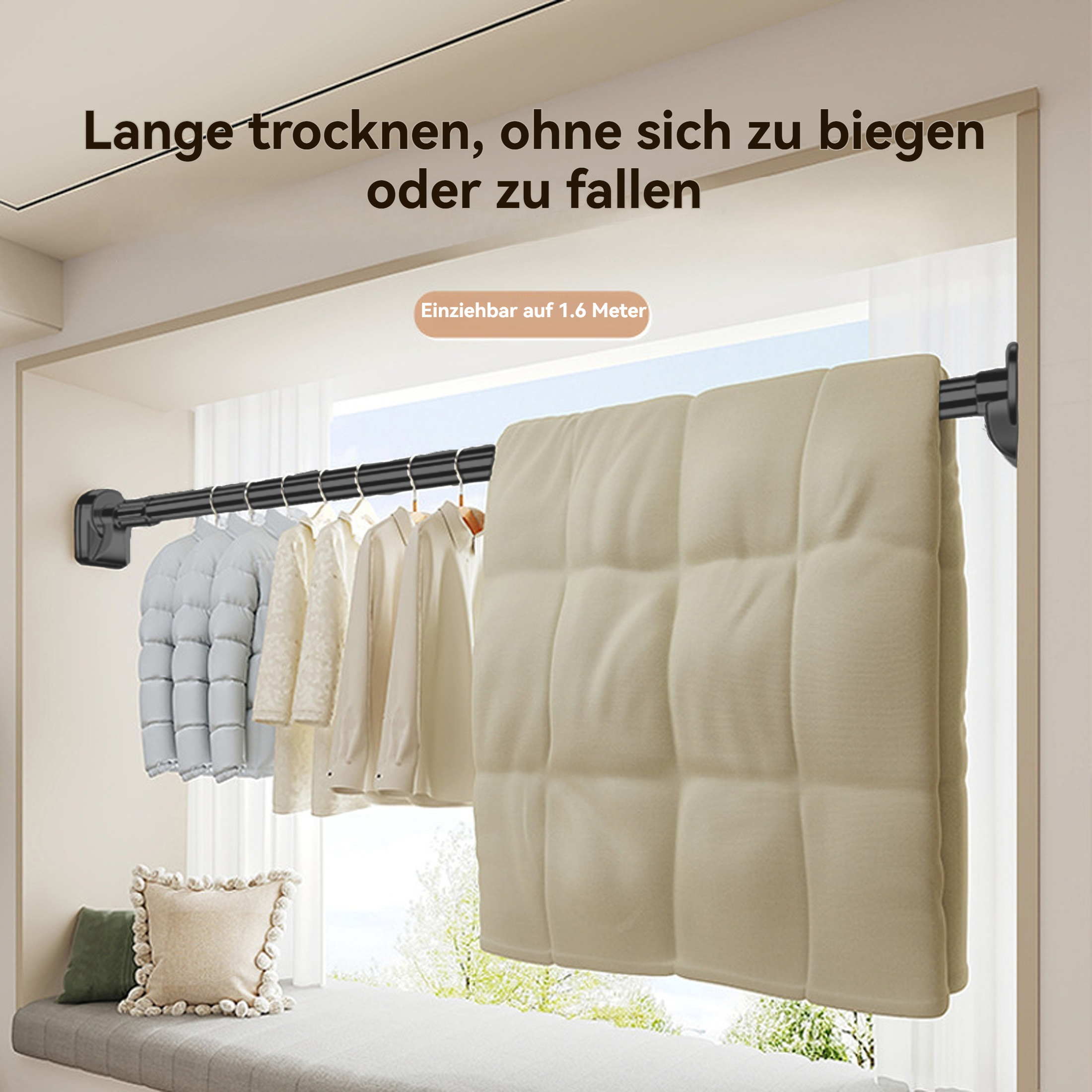 Kleidung hängt an einer Stange. Eine große beige Decke ist auf der Stange drapiert. Weiche Kissen auf der Fensterbank.