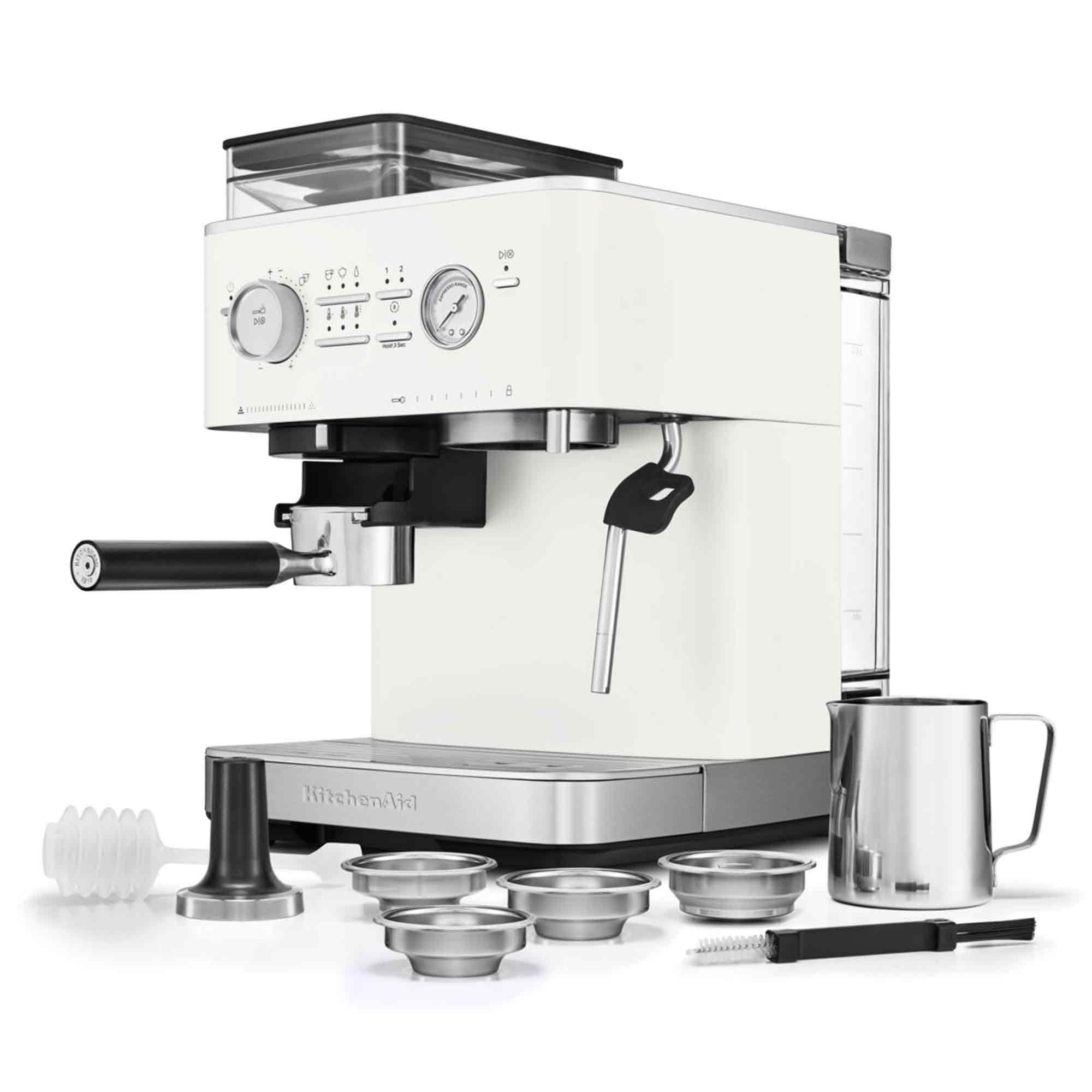 Een witte KitchenAid espressomachine met accessoires. Inclusief filterdrager, opschuimspuit en roestvrijstalen melkkan.