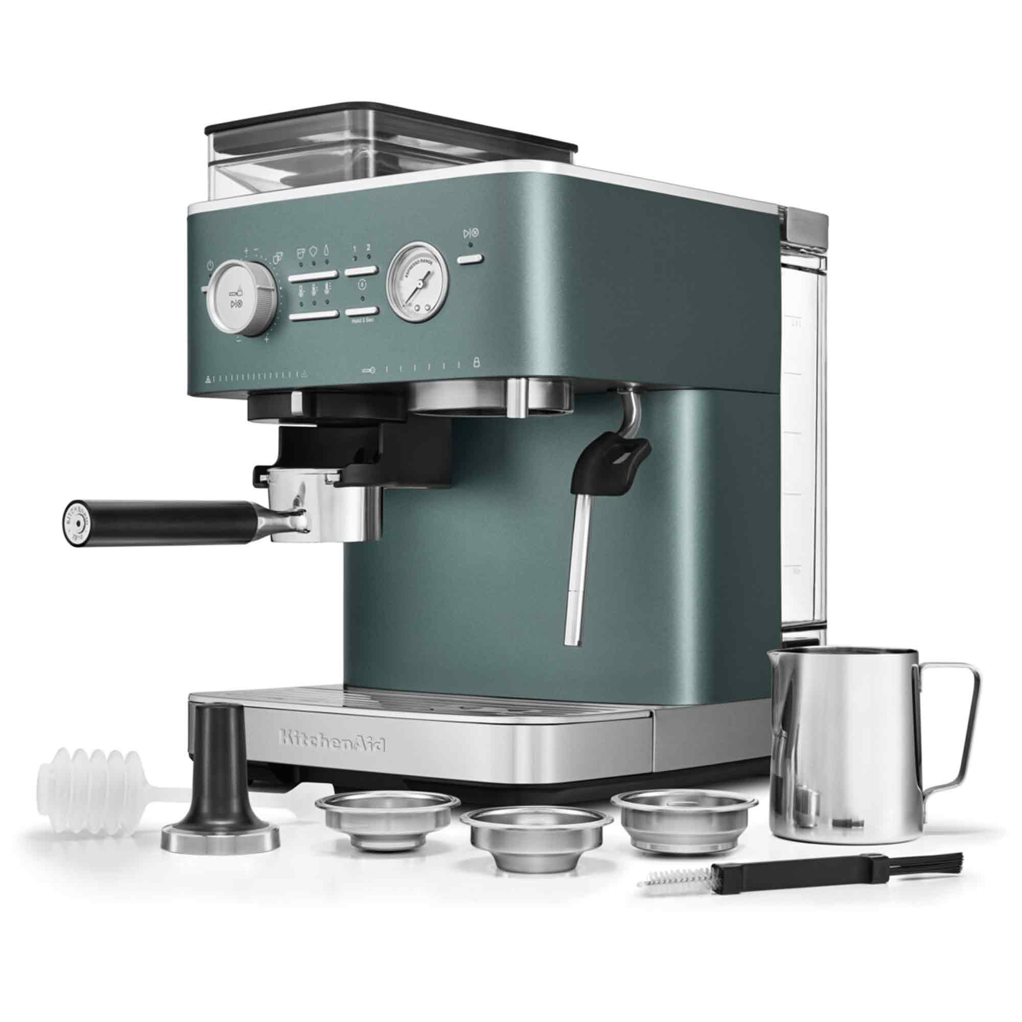 Eine türkisfarbene KitchenAid Espressomaschine wird angezeigt. Zubehör umfasst Metallbecher, einen Tamper, eine Bürste und einen Milchaufschäumkrug.