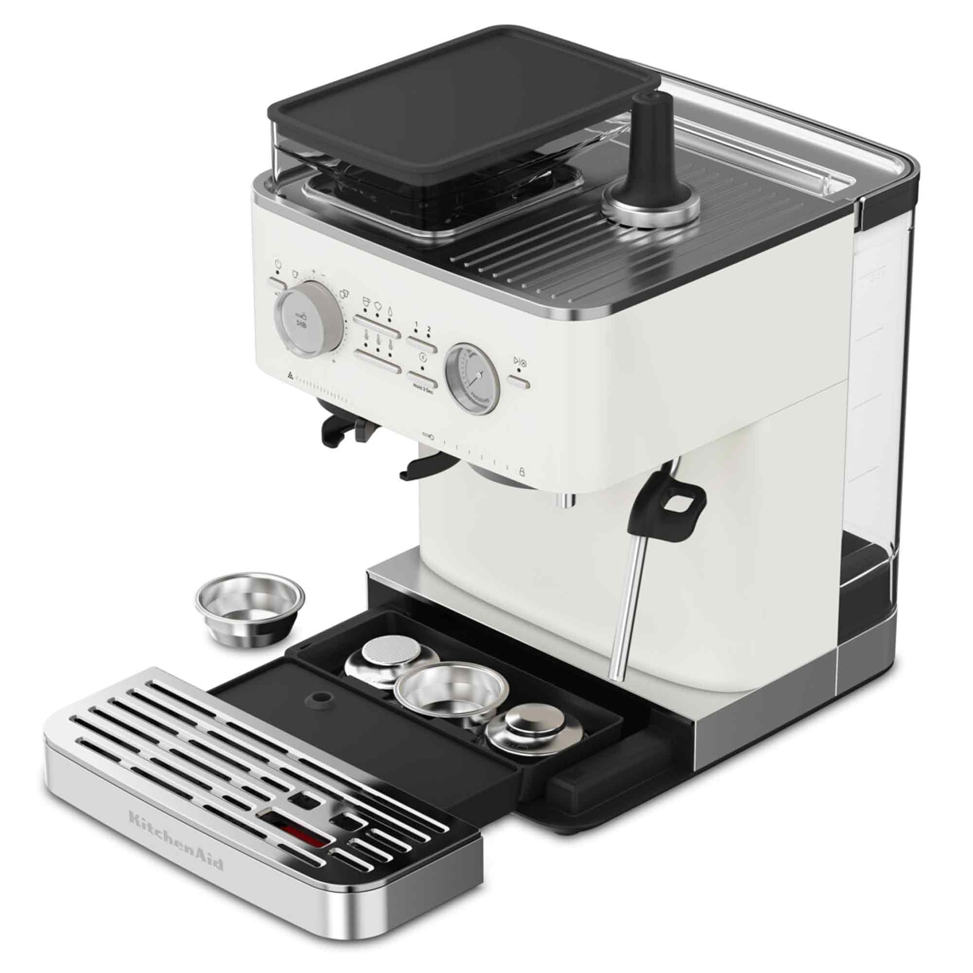 Een crèmekleurige KitchenAid espressomachine met zwarte accenten, een lade en diverse accessoires, tegen een witte achtergrond.