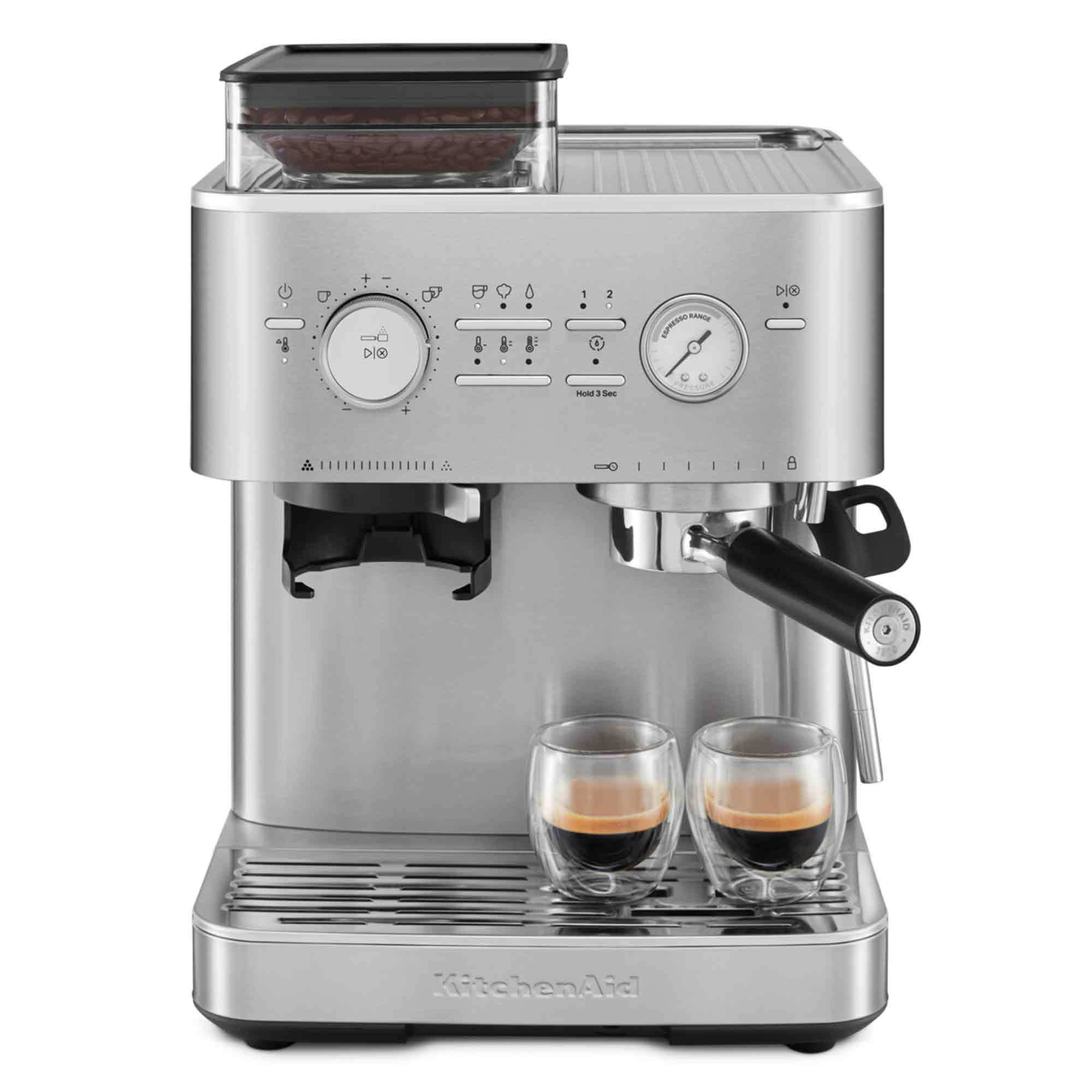 Eine silberne KitchenAid-Espressomaschine mit zwei Espresso-Shots in Gläsern. Ein Behälter für Kaffeebohnen befindet sich oben.