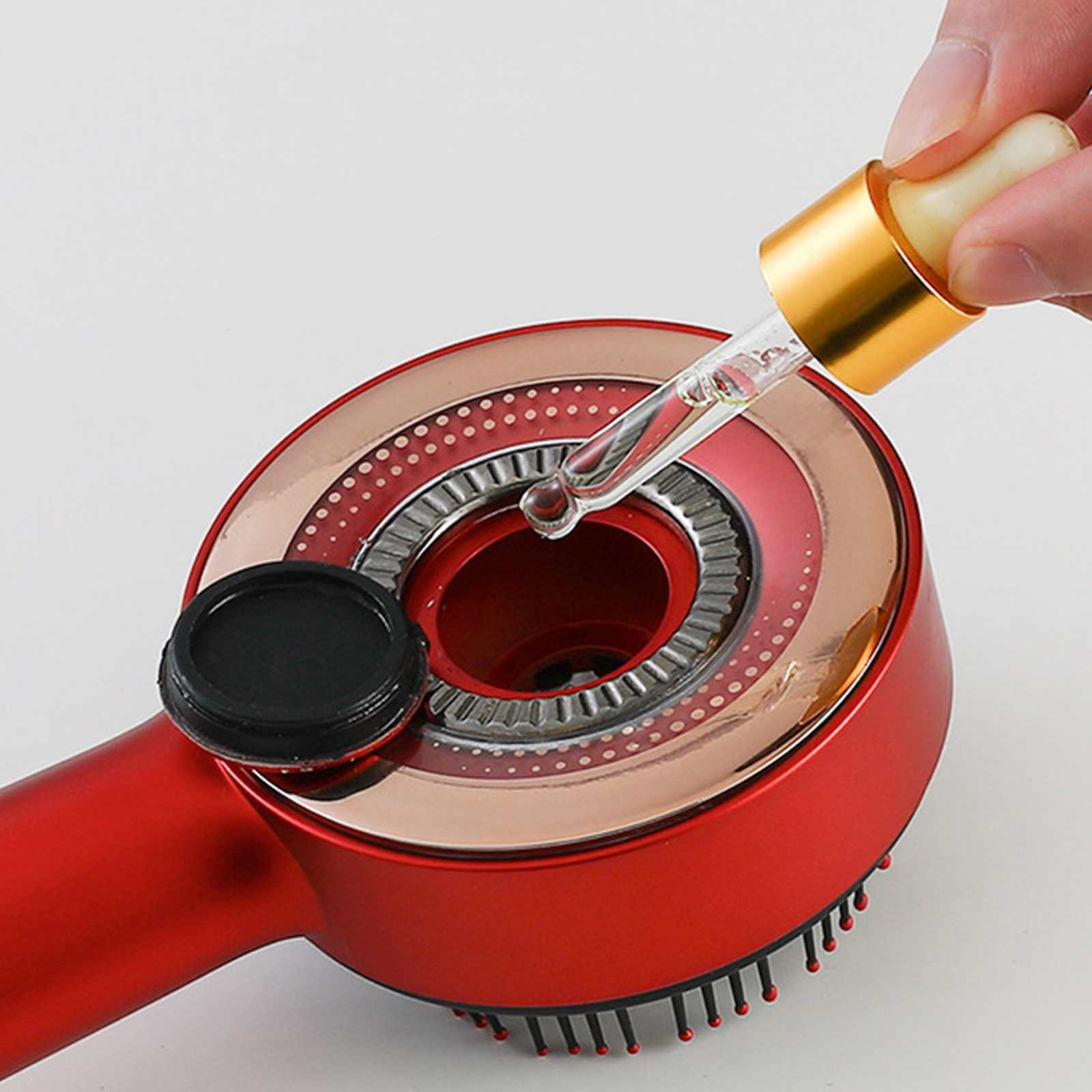 Ein rotes Schönheitsgerät mit einer Pipette, die Flüssigkeit abgibt. Eine Hand hält die Pipette. Schwarze Kappe links.