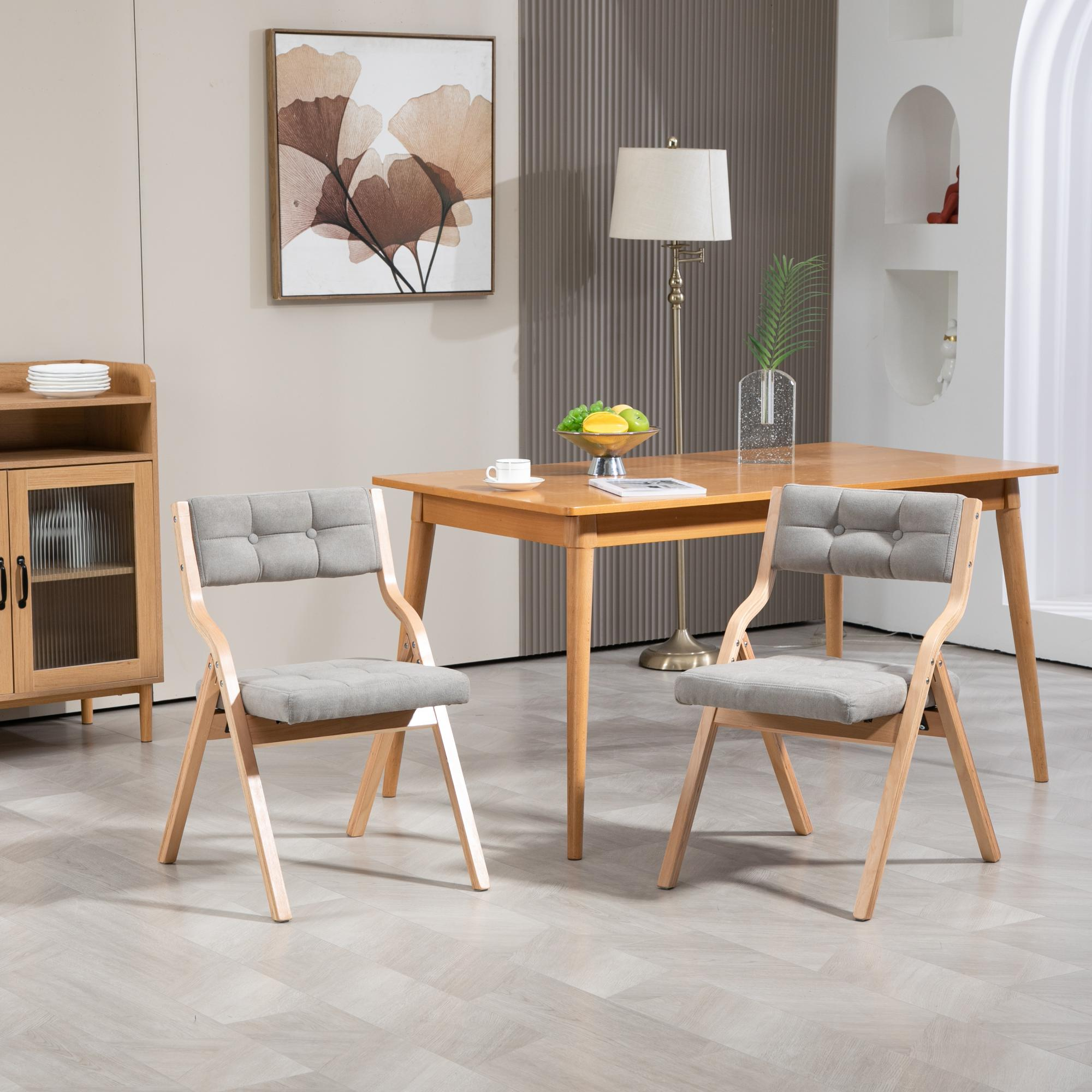 Ein Esszimmer mit Holztisch, zwei Stühlen, einem Schrank und einer Lampe. Ein Gemälde hängt an der Wand.