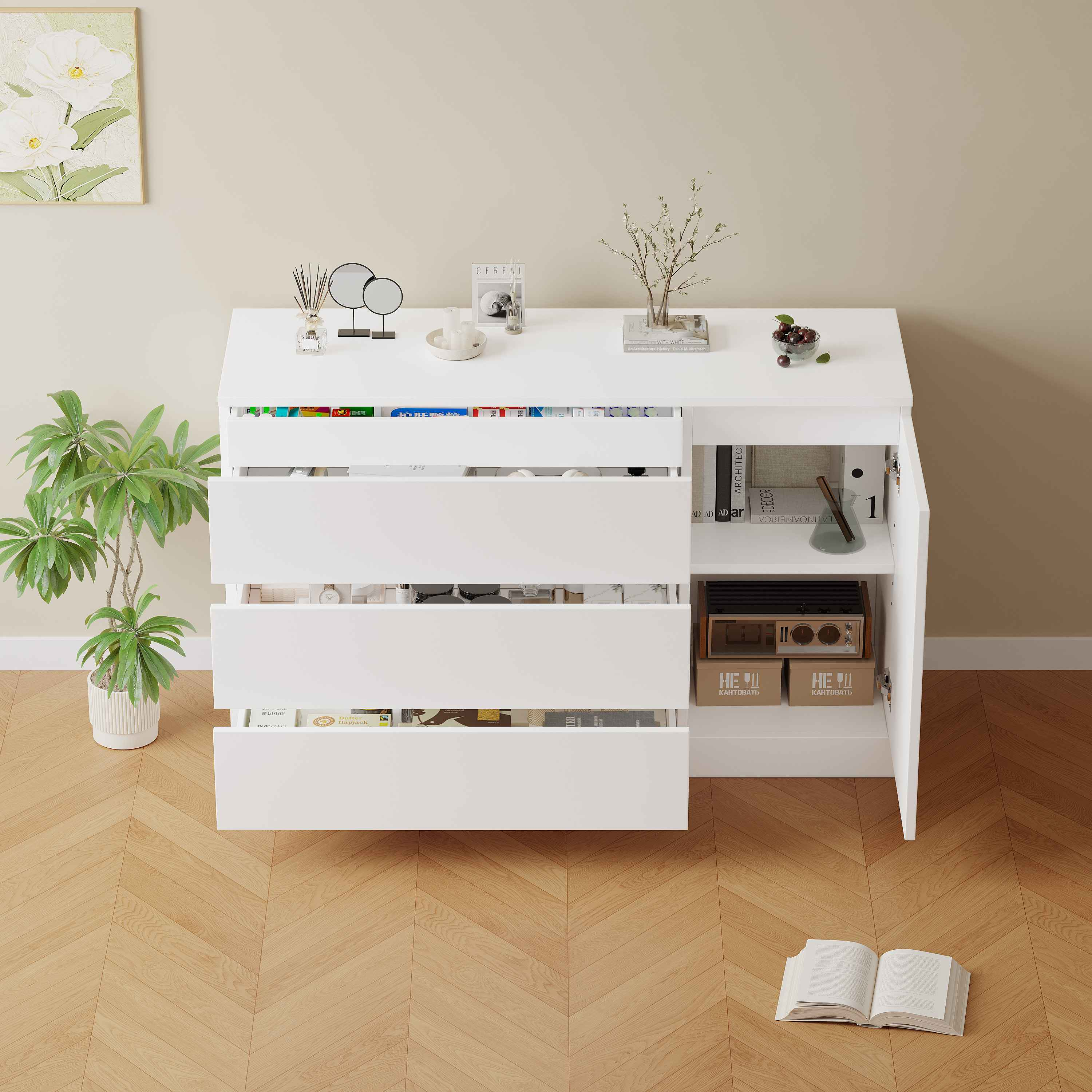 Ein weißer Schrank mit offenen Schubladen. Eine Pflanze, eine Vase mit Blumen und ein offenes Buch befinden sich auf oder um den Schrank.