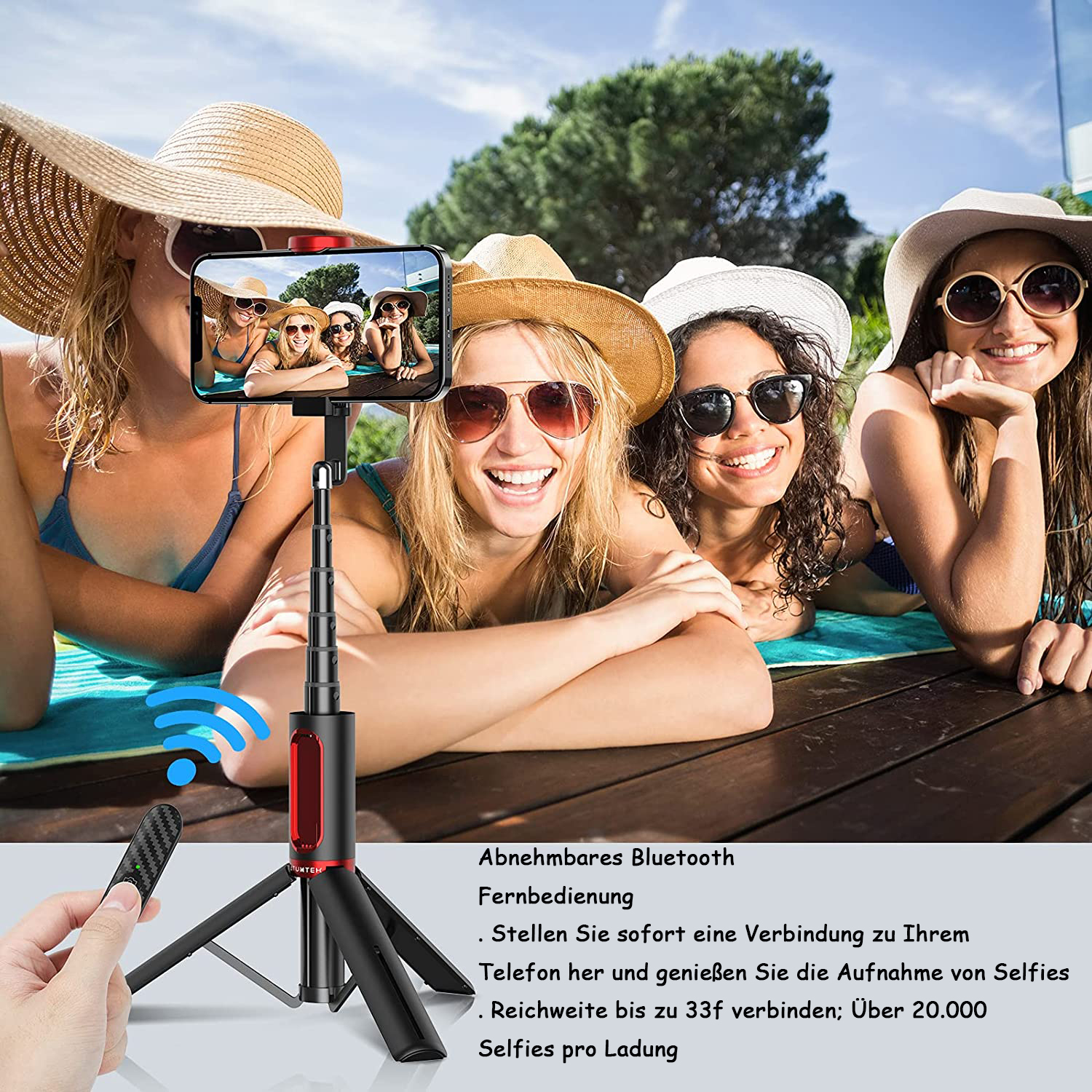 Vier Frauen mit Hüten und Sonnenbrillen posieren für ein Selfie. Ein Selfie-Stick ist im Vordergrund, und eine Bluetooth-Fernbedienung wird gehalten.