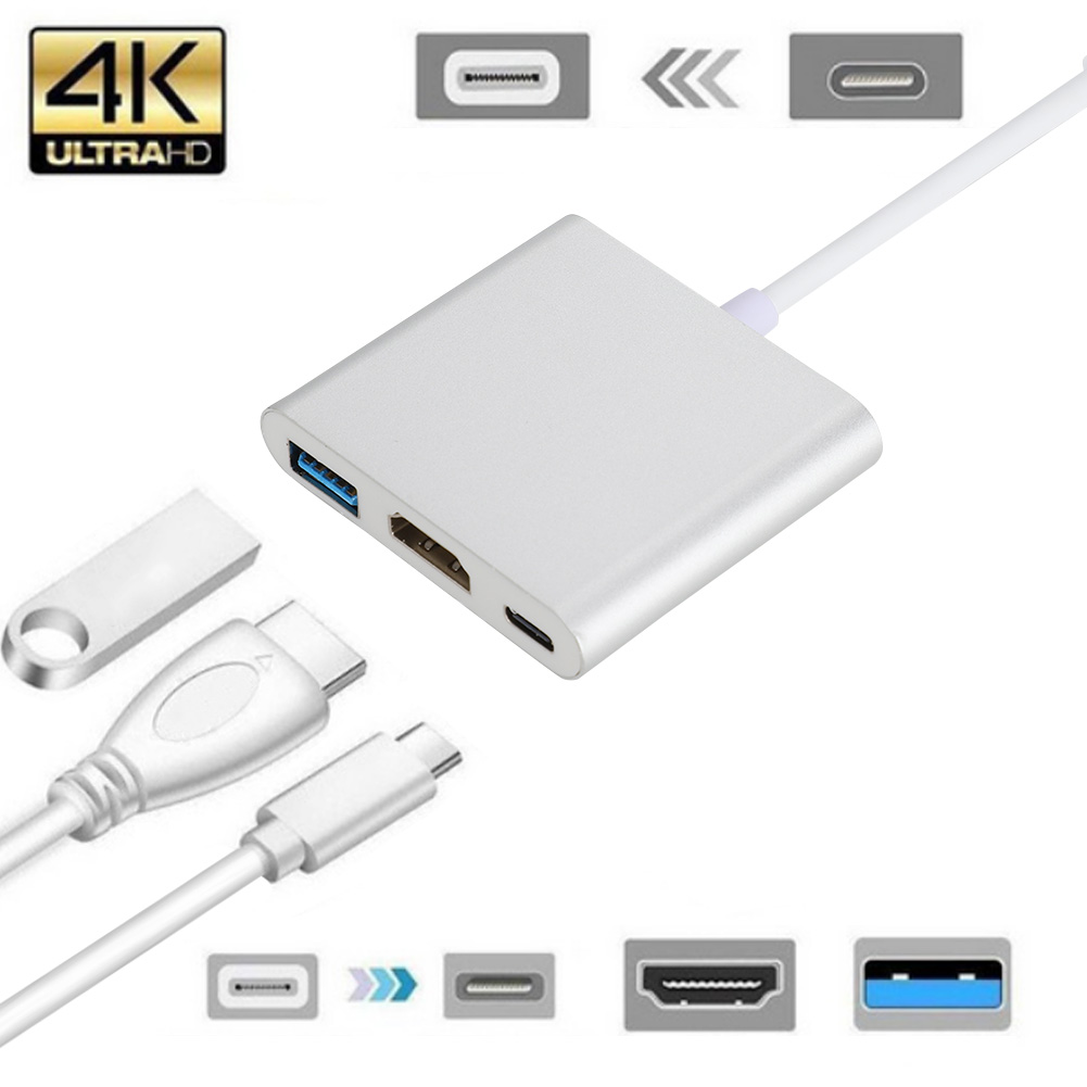 Ein silberner Adapter mit USB-, HDMI- und USB-C-Anschlüssen. Kabel und ein USB-Laufwerk sind abgebildet. Icons für verschiedene Anschlüsse.