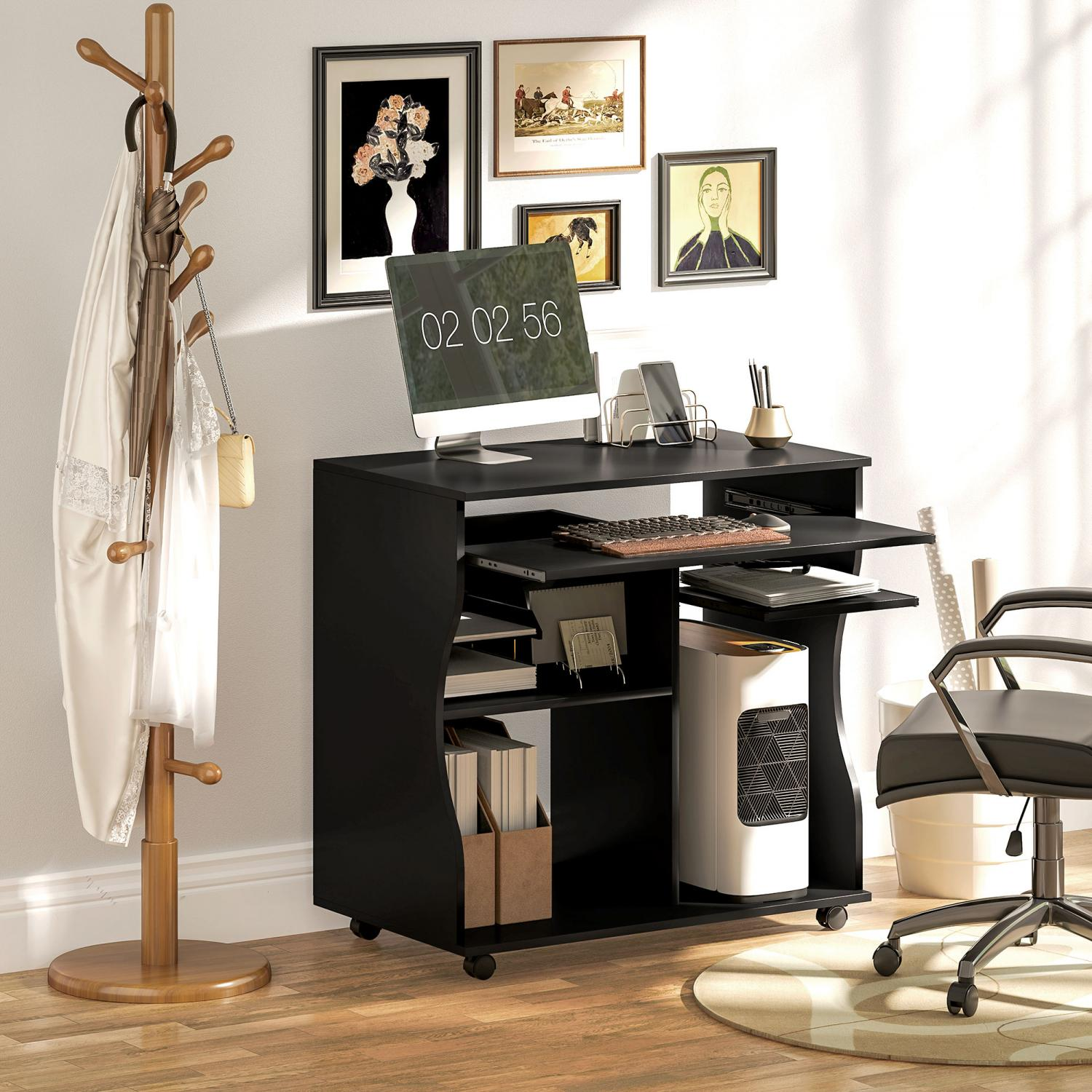 Schwarzer Schreibtisch mit Computer, Bildern an der Wand, Garderobenständer und Stuhl. Der Schreibtisch hat eine Tastatur und einen Computer.