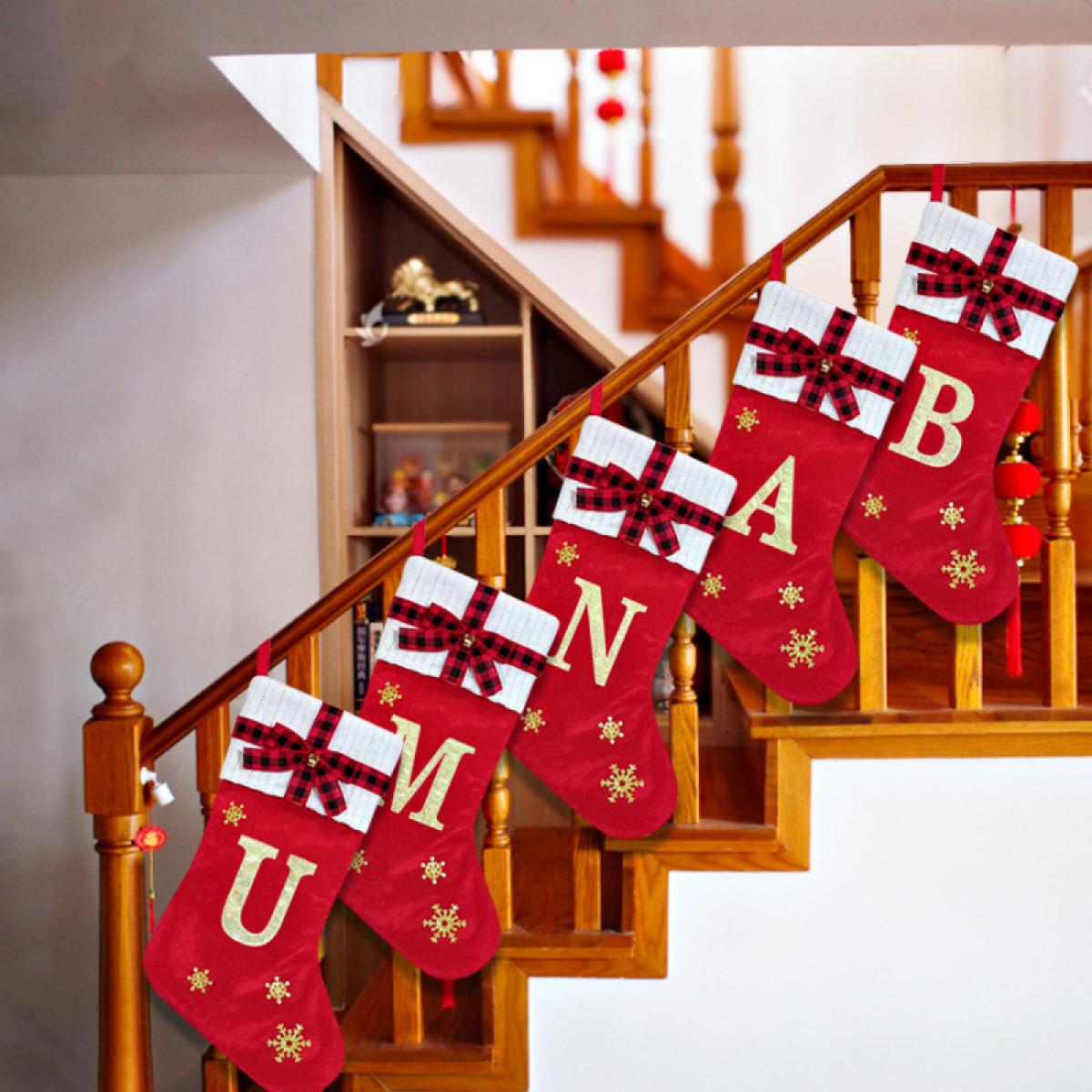 Rote Weihnachtsstrümpfe mit einem Namen, die an einer Holztreppe hängen. Jeder hat einen Buchstaben, eine Schneeflocke und eine Schleife.
