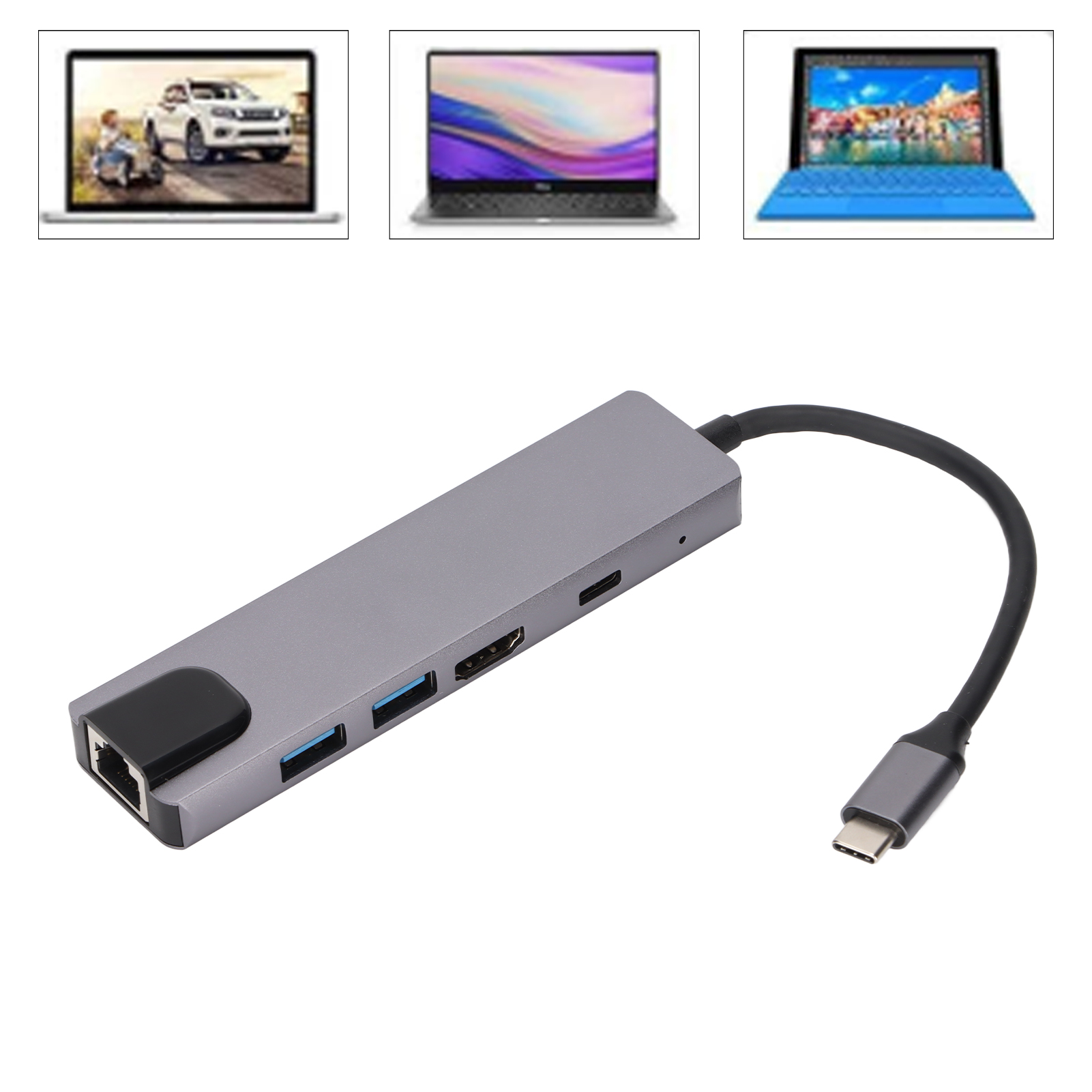 Grauer USB-Hub mit mehreren Anschlüssen und einem schwarzen Kabel. Im Hintergrund sind drei Laptops.
