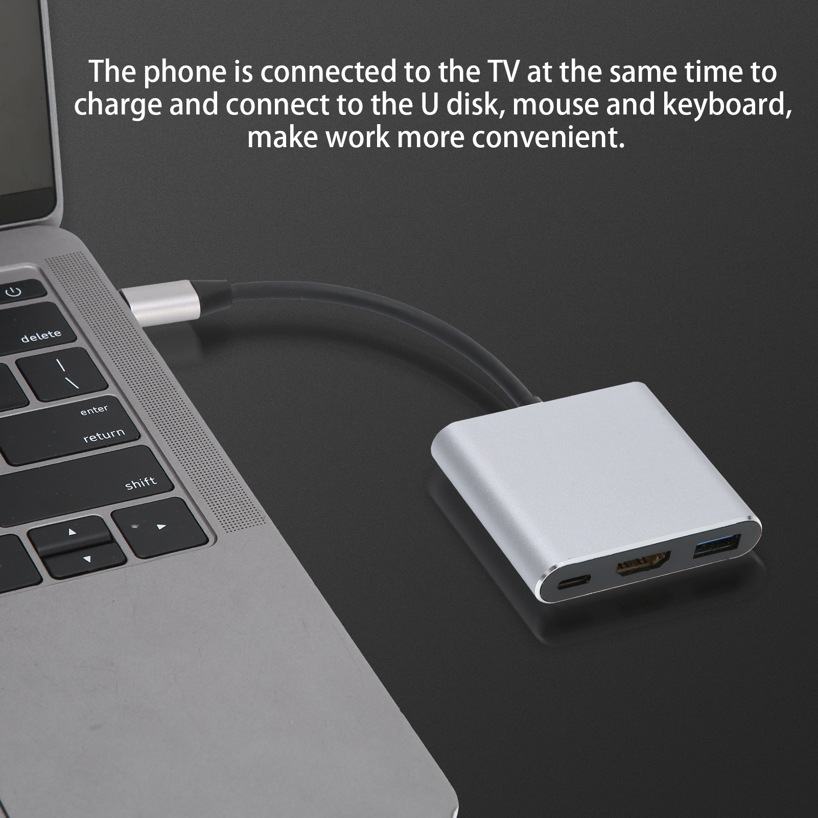 Laptop mit Adapter verbunden. Der Adapter hat Anschlüsse für USB, HDMI und Laden. Schwarzes Kabel verbindet sie.
