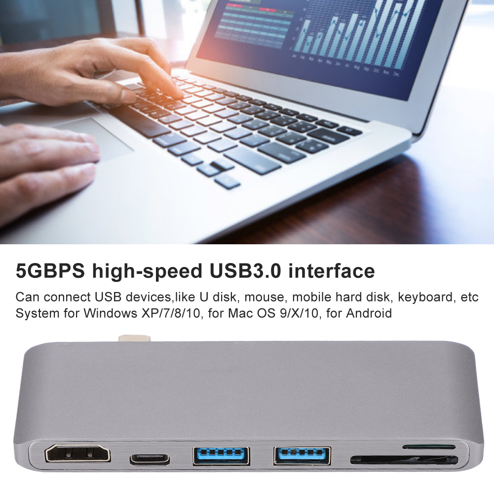 Eine Person benutzt einen Laptop mit einem USB-Hub darunter. Der Hub hat mehrere Anschlüsse. Der Laptop-Bildschirm zeigt ein Diagramm.