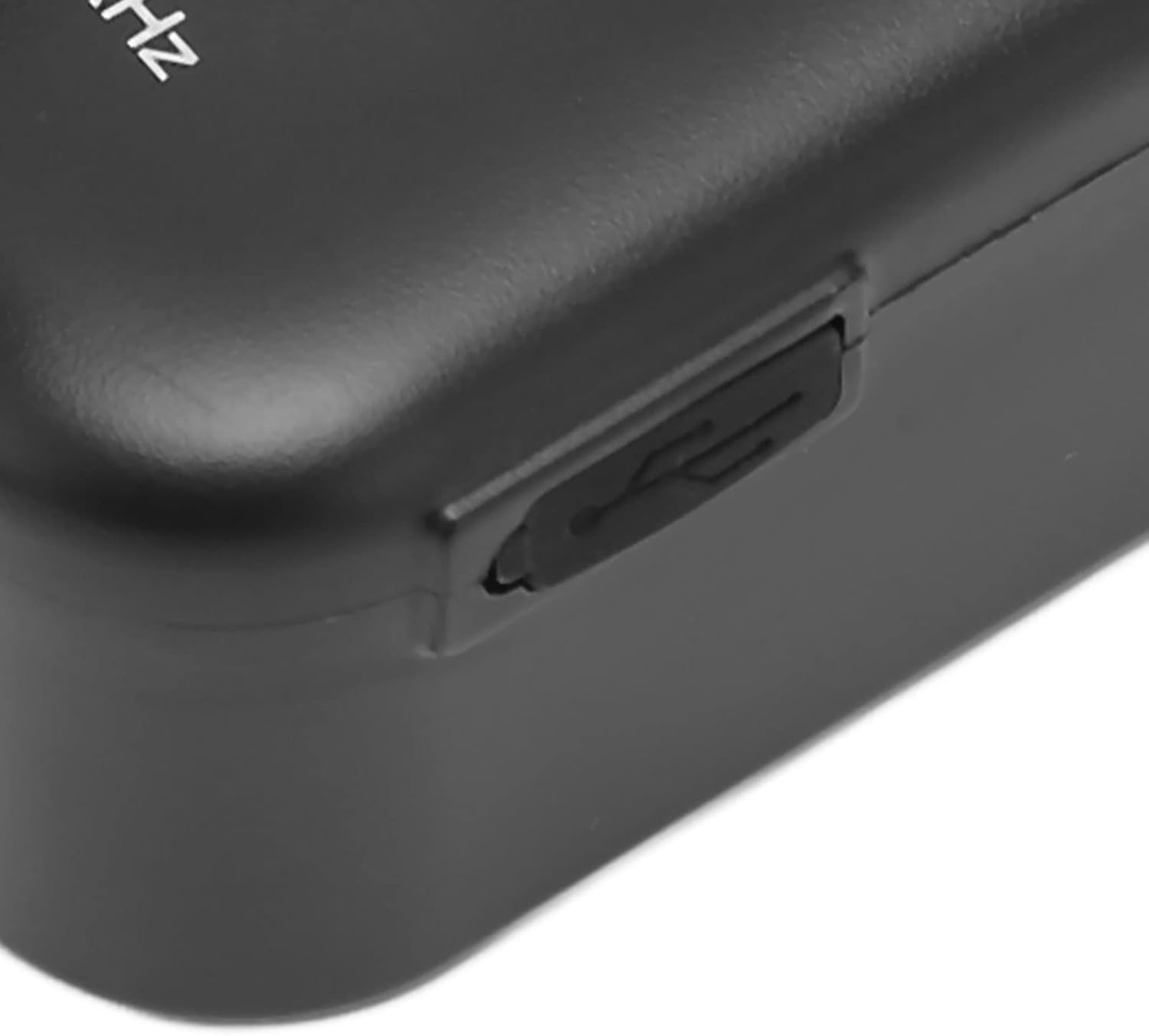 Nahaufnahme eines schwarzen elektronischen Geräts mit USB-Anschluss. Das Gerät hat eine glatte Oberfläche und der Anschluss ist rechteckig.