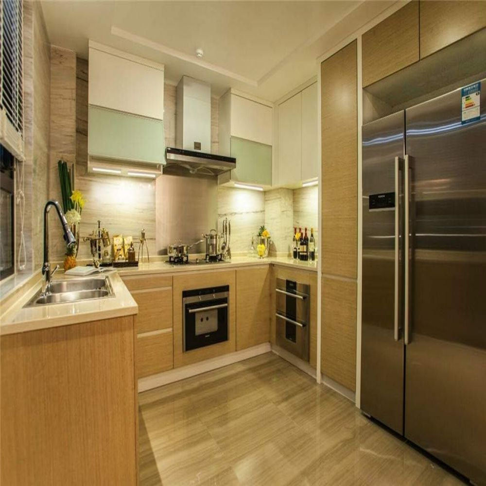 Moderne Küche mit hellen Holzschränken, Edelstahlgeräten, Marmorspritzschutz und einem großen Kühlschrank.