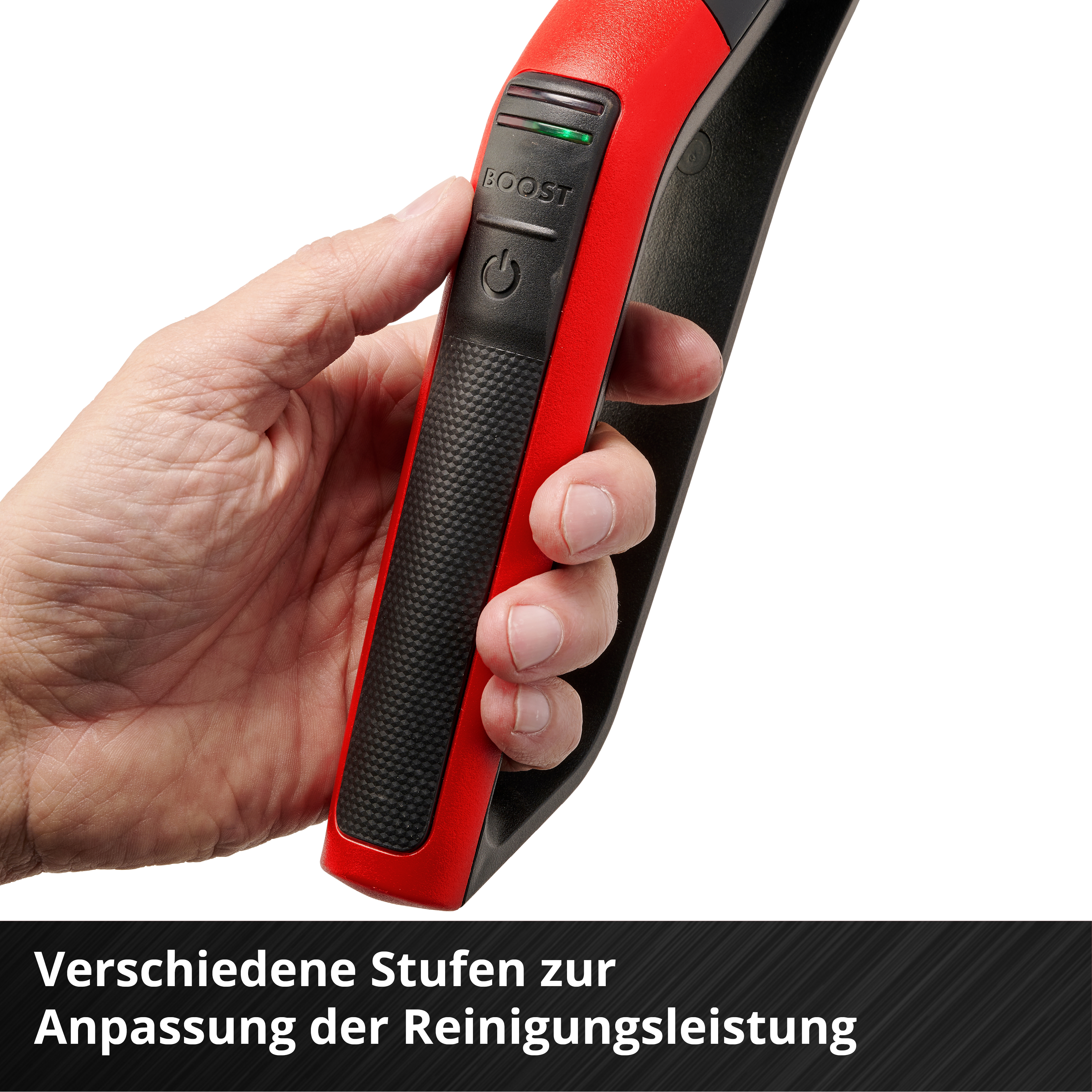 Eine Hand hält ein rot-schwarzes Gerät. Das Gerät hat eine Boost-Taste mit einem grünen Licht.