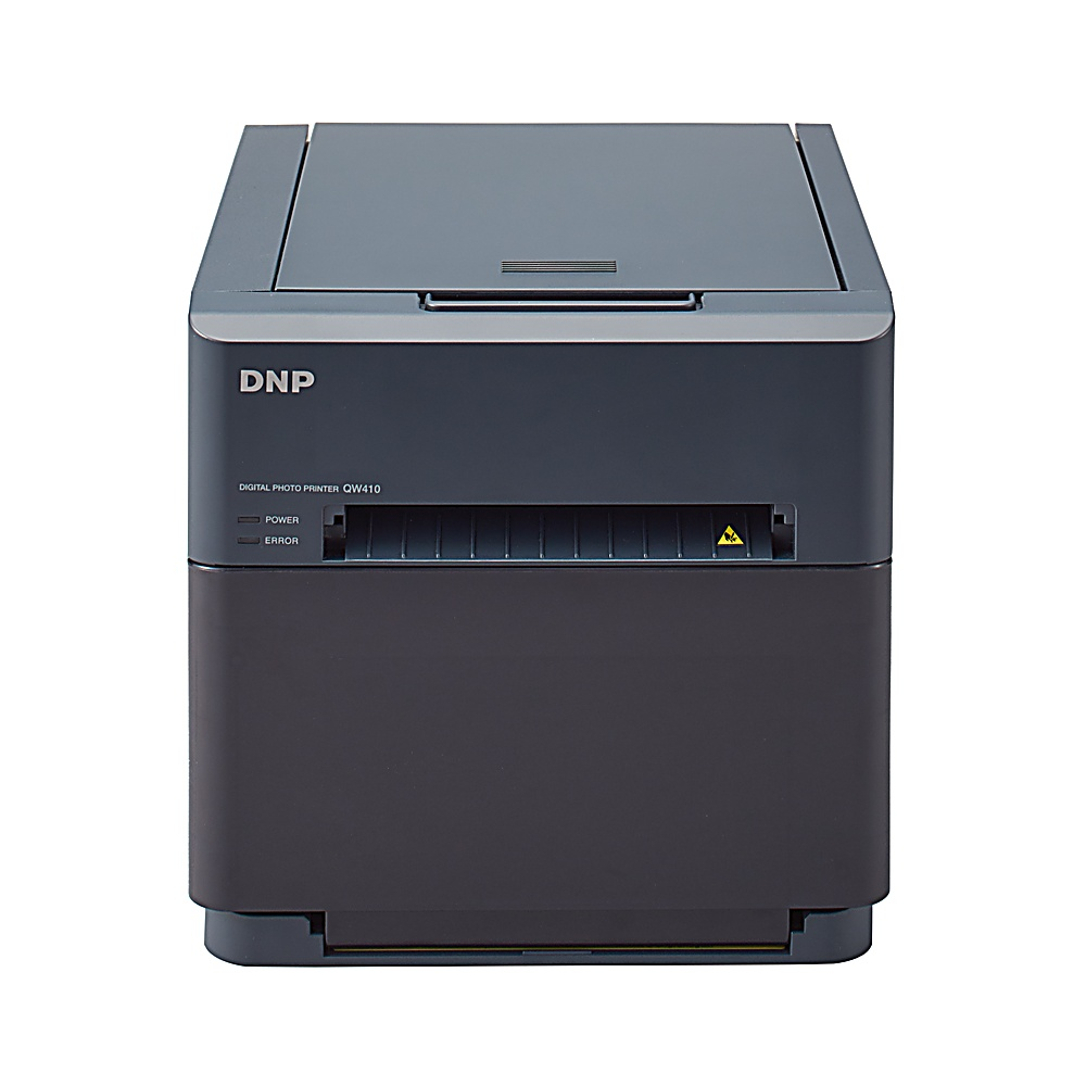 Una impresora de fotos digital DNP QW410 gris oscuro sobre fondo blanco. Tiene luces de encendido/error, ranura de salida de papel y tapa superior.