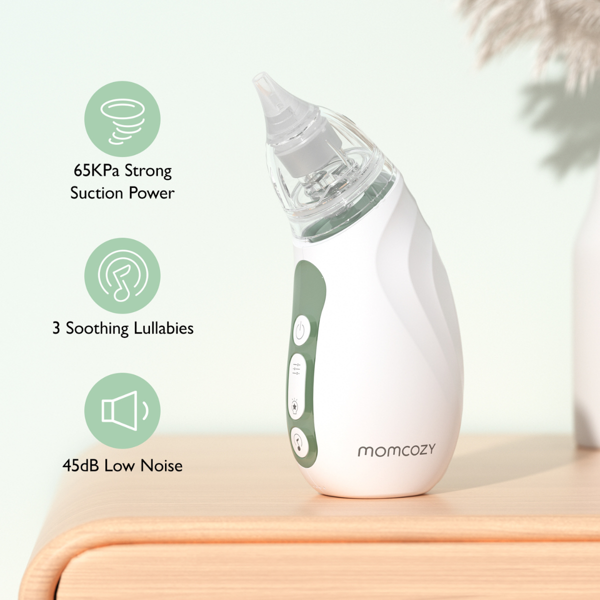 White and green baby nasal aspirator on a wooden surface with text about suction power, lullabies, and low noise.