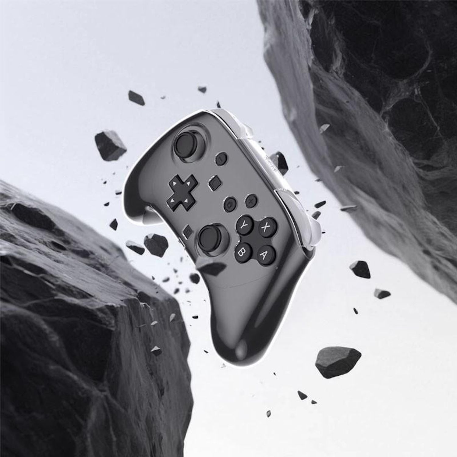 Ein grauer Gamecontroller schwebt inmitten fallender Steine. Der Controller hat Knöpfe und ein Steuerkreuz. Der Hintergrund ist hell.