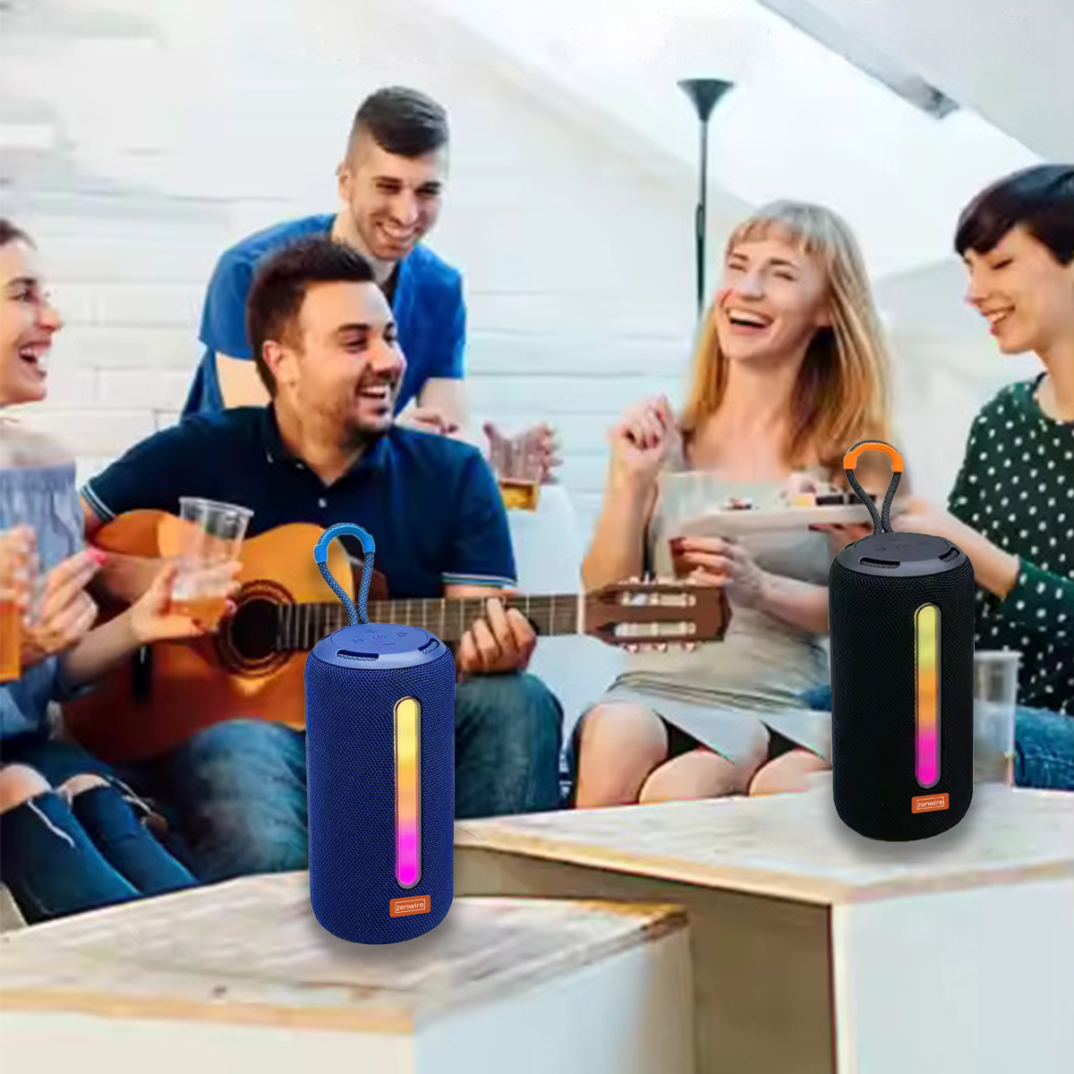 Grupa przyjaciół śmieje się razem, niektórzy trzymają napoje i gitarę. Dwa głośniki stoją na stole.