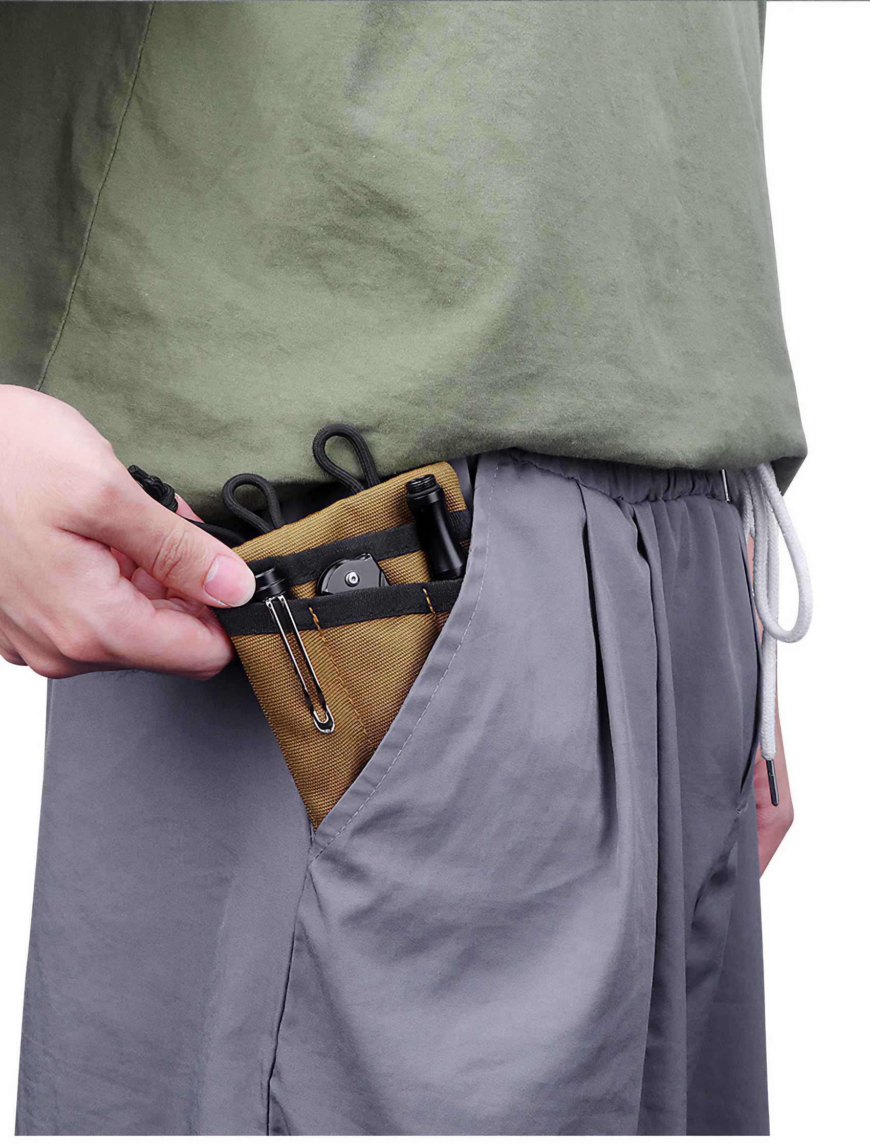 Die Hand einer Person greift in eine Tasche und hält einen braunen Beutel mit einem Messer und einer Taschenlampe.