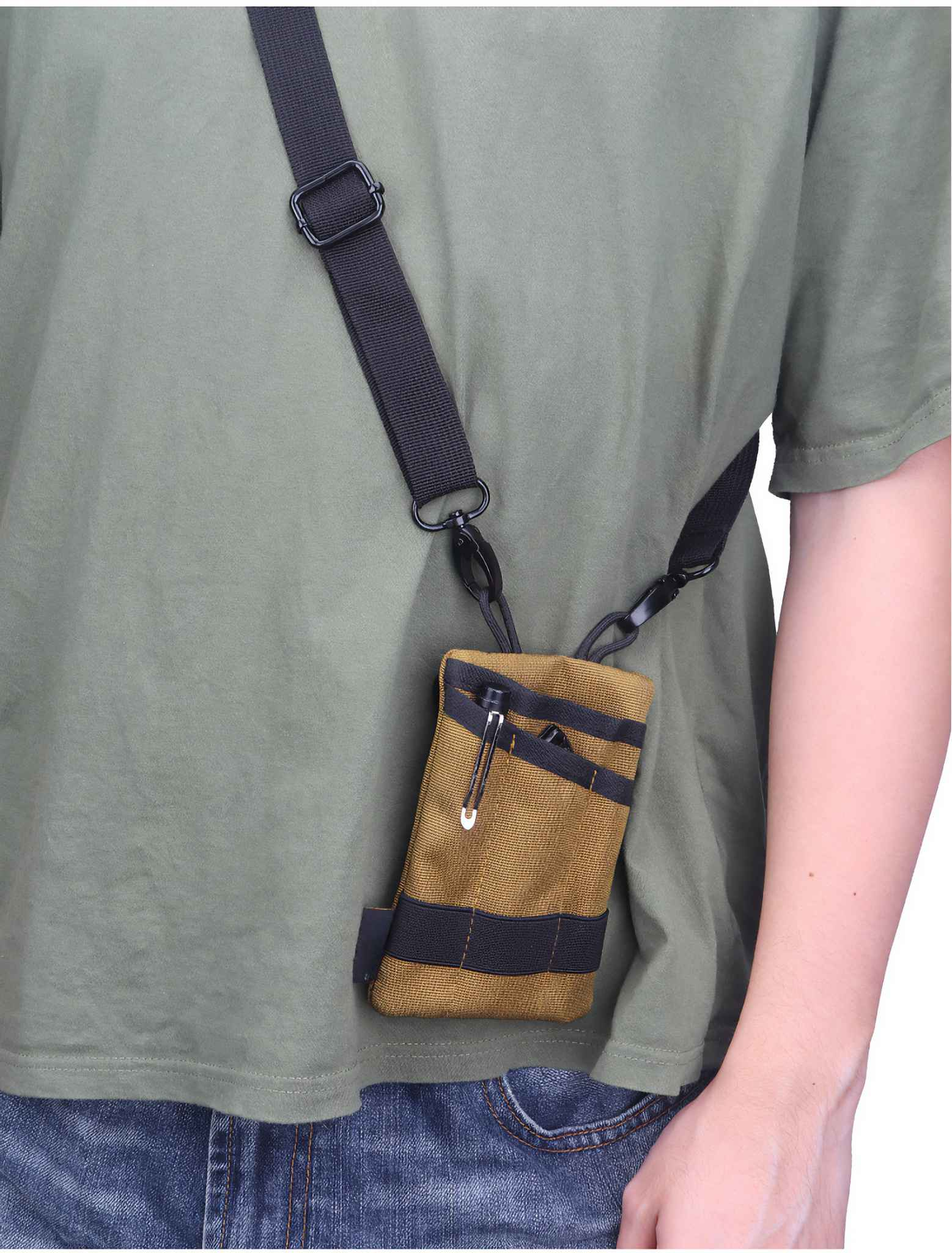 Eine Person trägt ein grünes Hemd mit einer braunen Tasche, die an einem schwarzen Riemen über ihrem Körper hängt. Die Tasche hat schwarze Streifen.