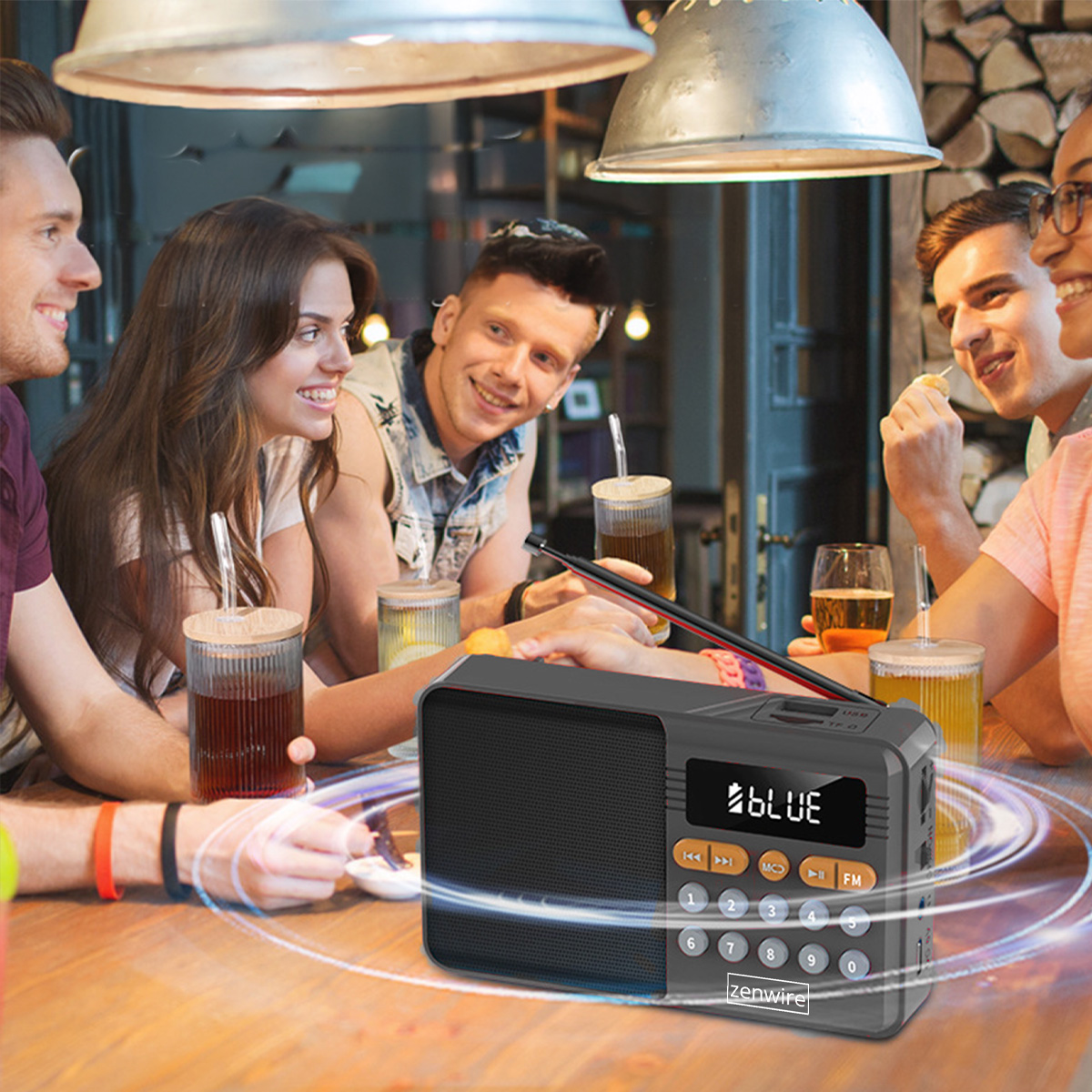 Grupa znajomych przy stole z napojami, radio na pierwszym planie. Ludzie się uśmiechają i rozmawiają.